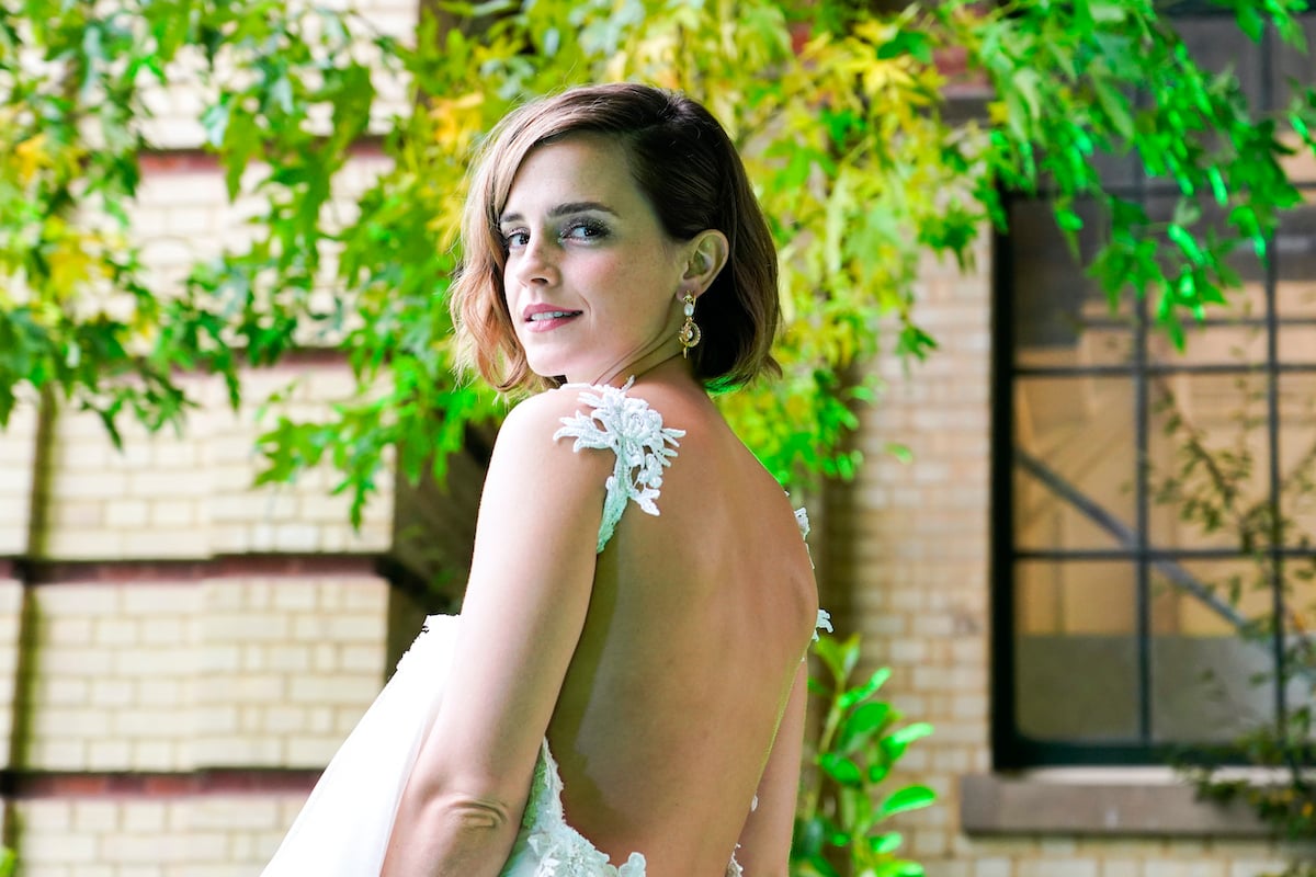 college grad Emma Watson looks over her shoulder in a white dress