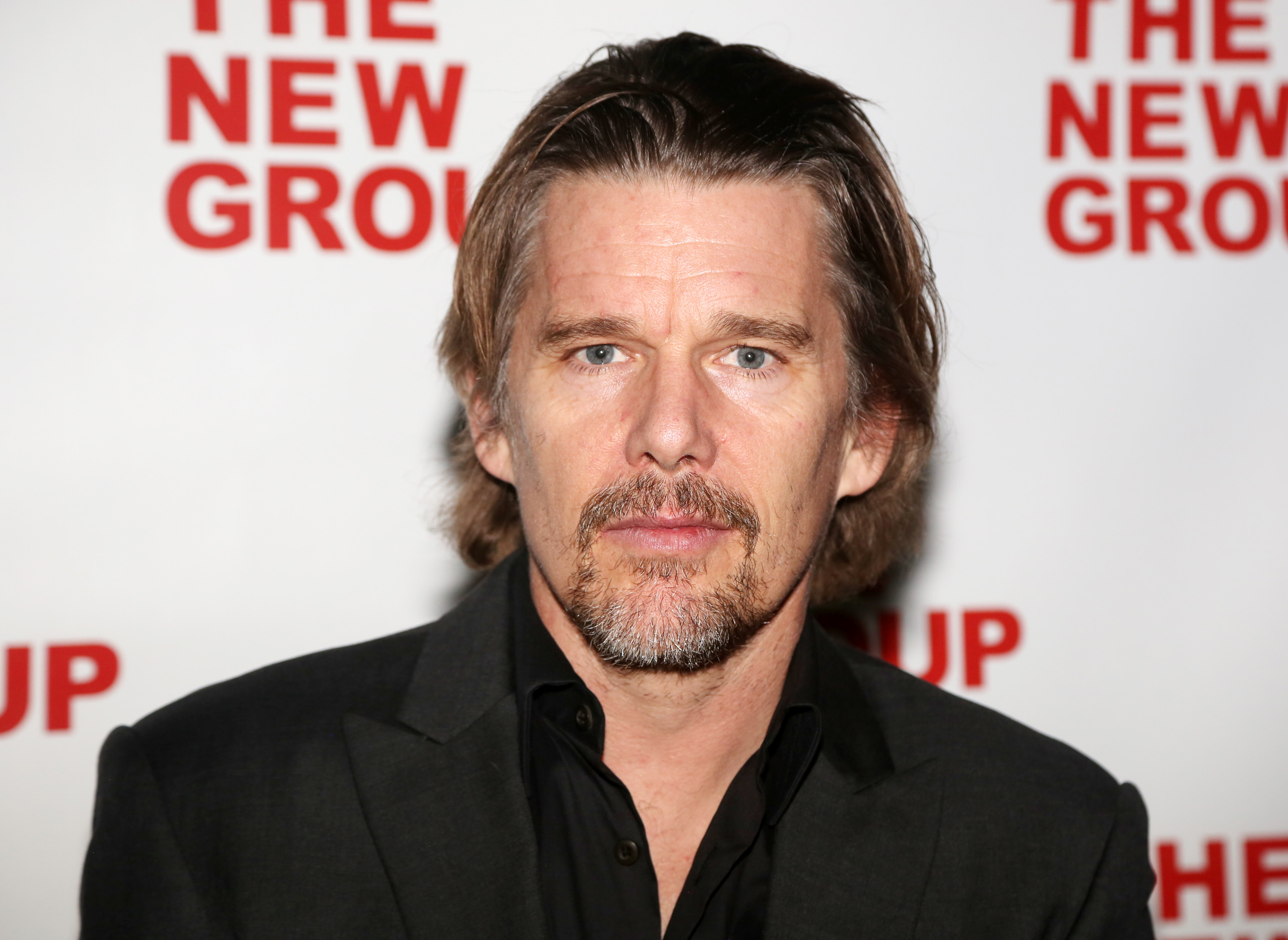 'Moon Knight' actor Ethan Hawke wears a black suit jacket over a black button-up shirt.
