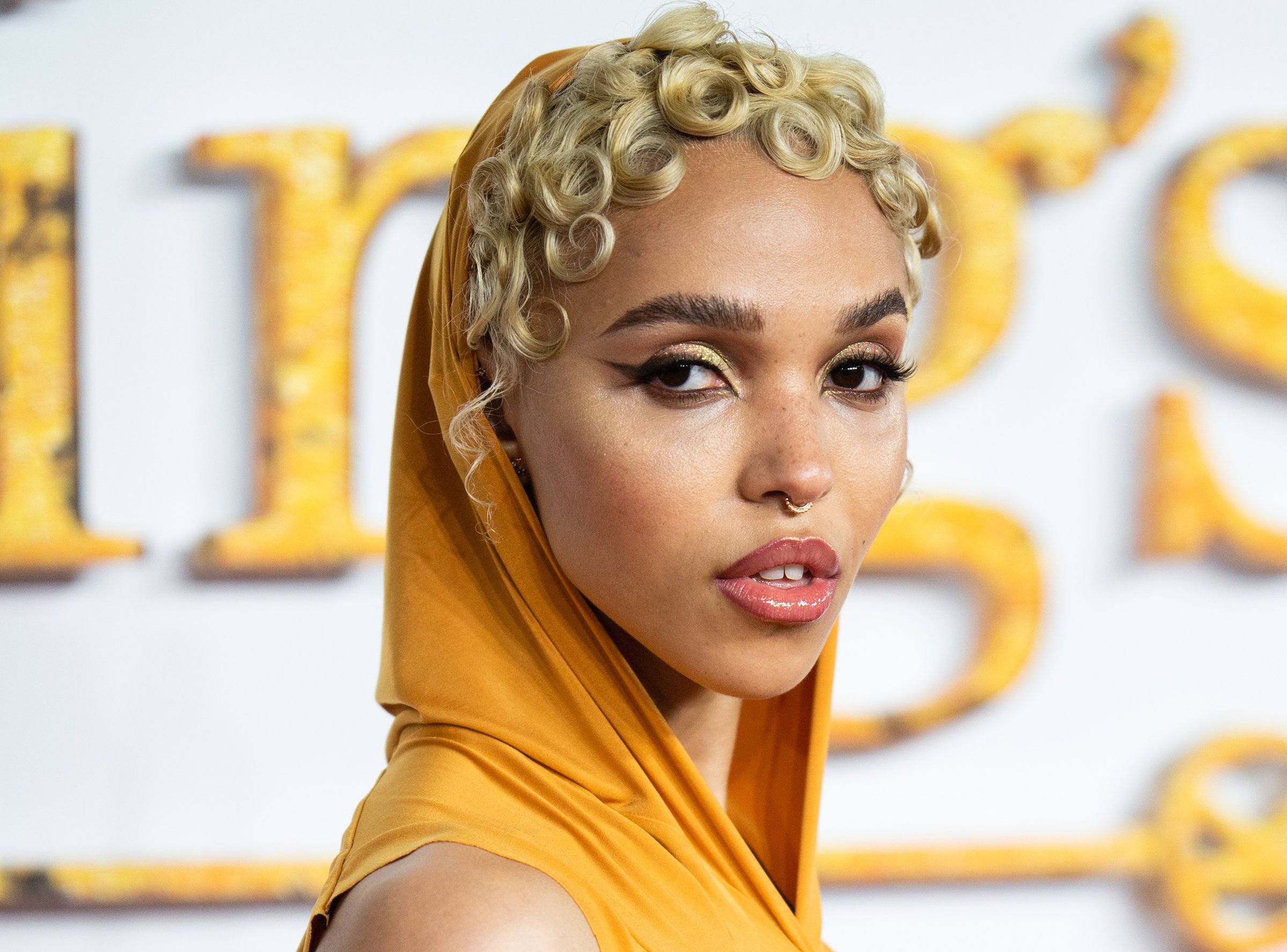 FKA twigs wearing an orange hood