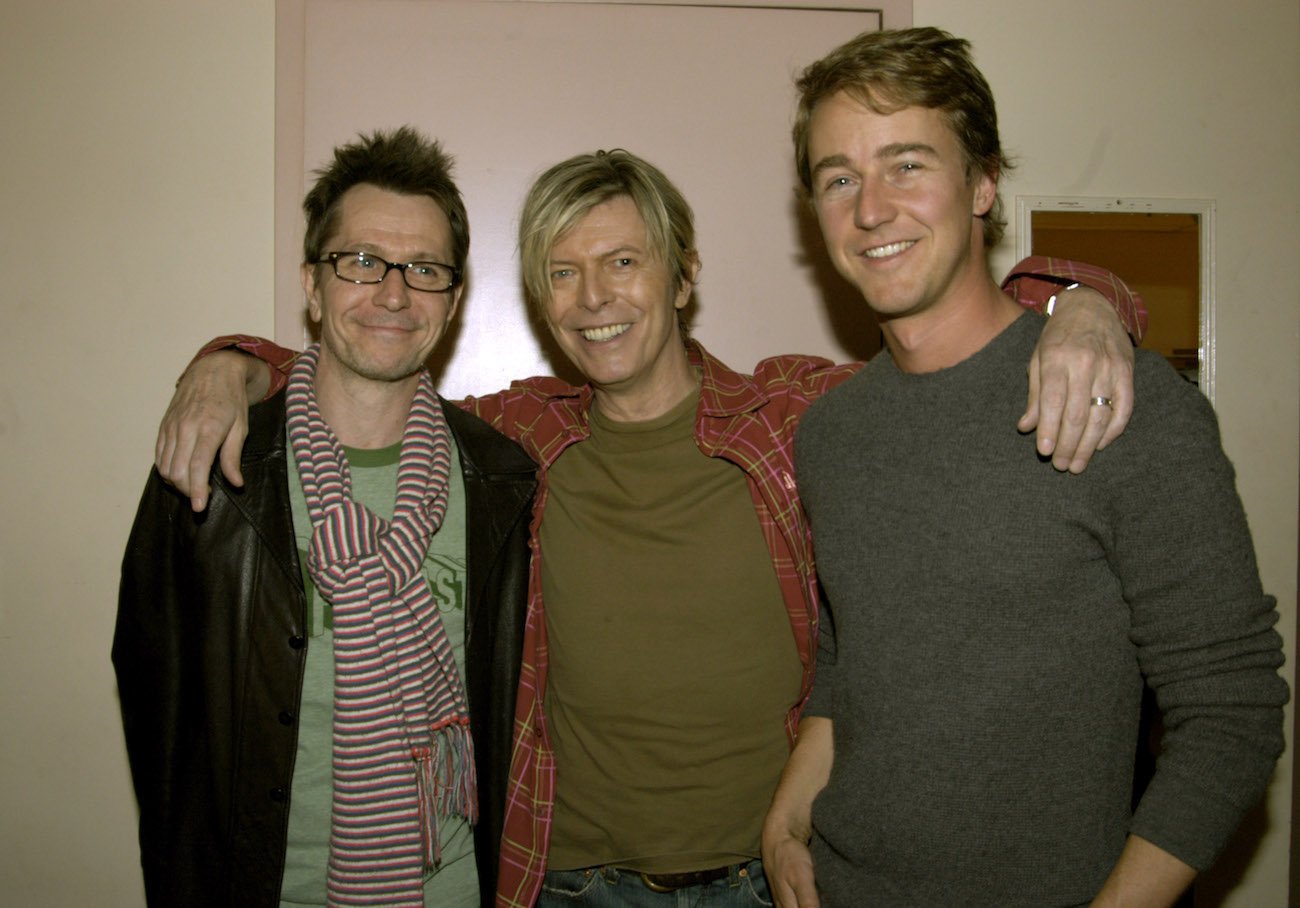 Gary Oldman, David Bowie, and Edward Norton posing for the camera in 2004.