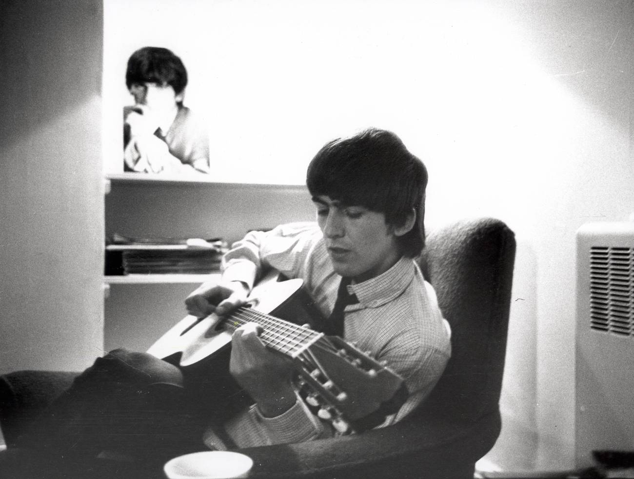 George Harrison playing guitar at Twickenham Film Studios while filming 'A Hard Day's Night' in 1964.