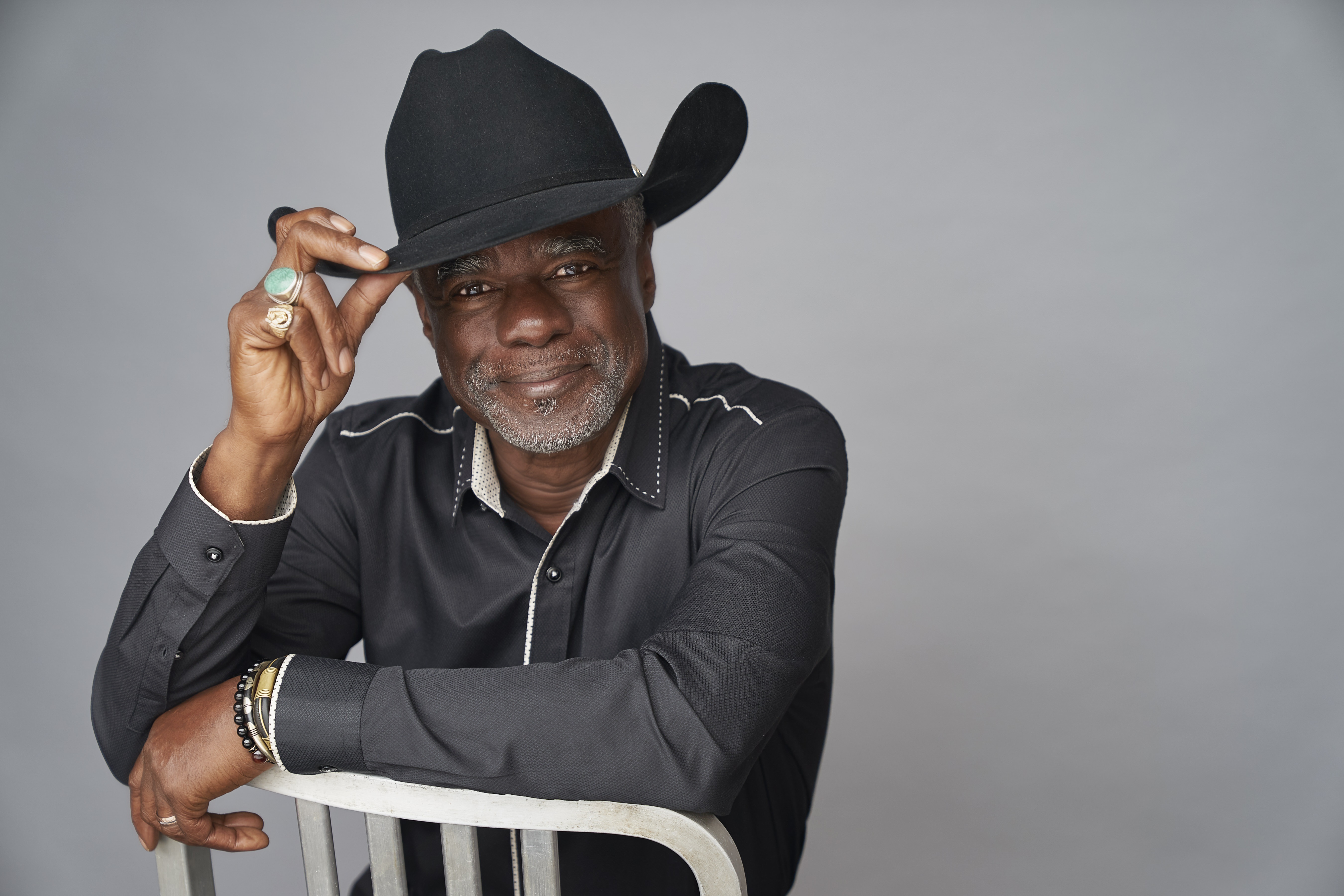 Glynn Turman posing with his hand on the brim of his hat