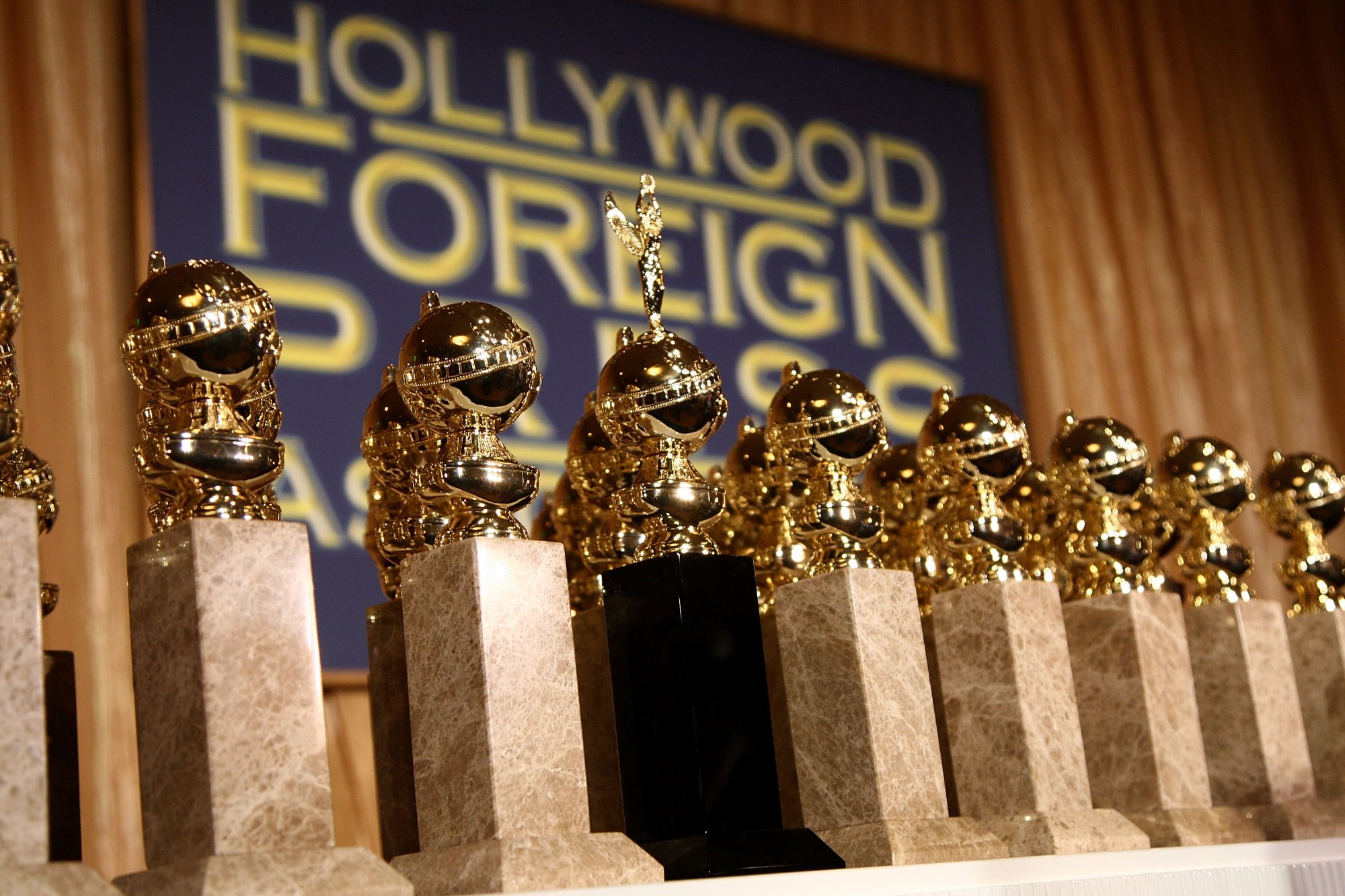 Golden Globes 2022 statues in front of the Hollywood Foreign Press Association logo