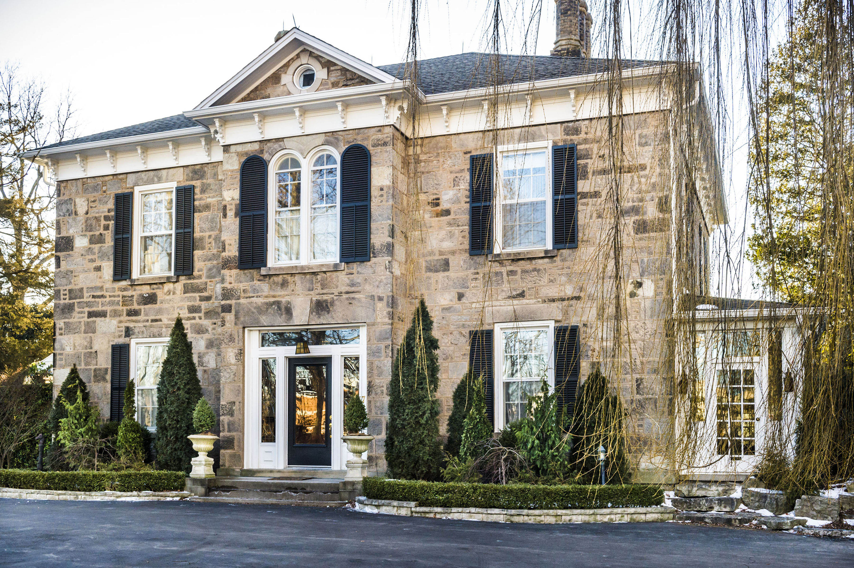 Exterior of Grey House, a grey brick home with black shutters, from the Hallmark Channel series 'Good Witch'