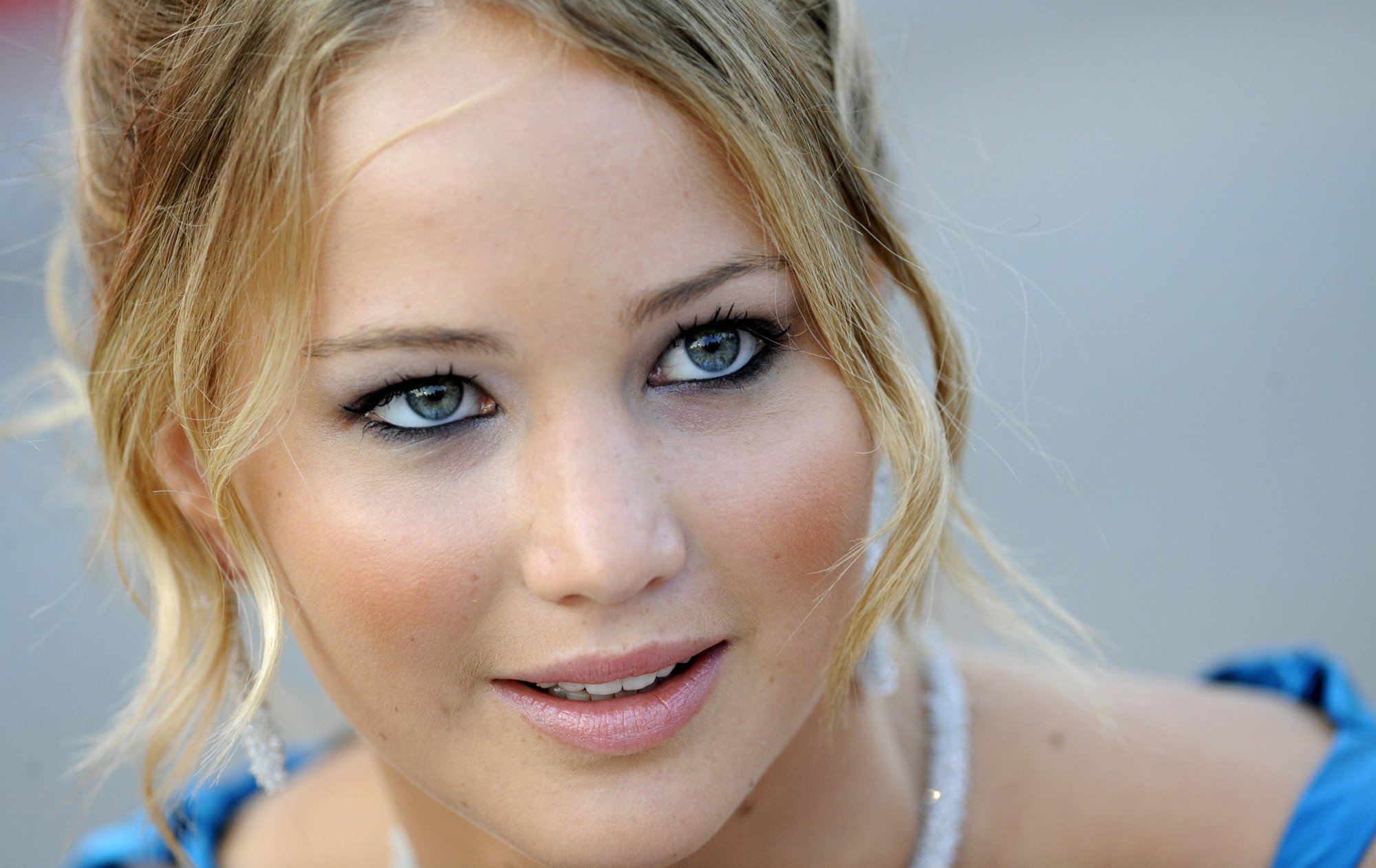 closeup of the face of 'House at the End of the Street' horror movie star Jennifer Lawrence, wearing blue and earrings