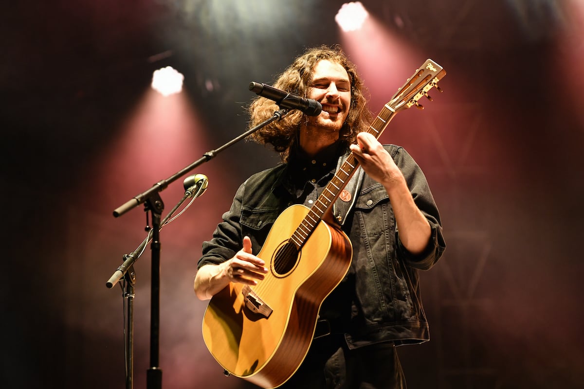 Hozier singing, playing guitar on stage