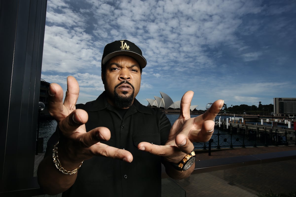 Ice Cube wears black and holds his hands to the camera as he poses in front of the Sydney Opera House