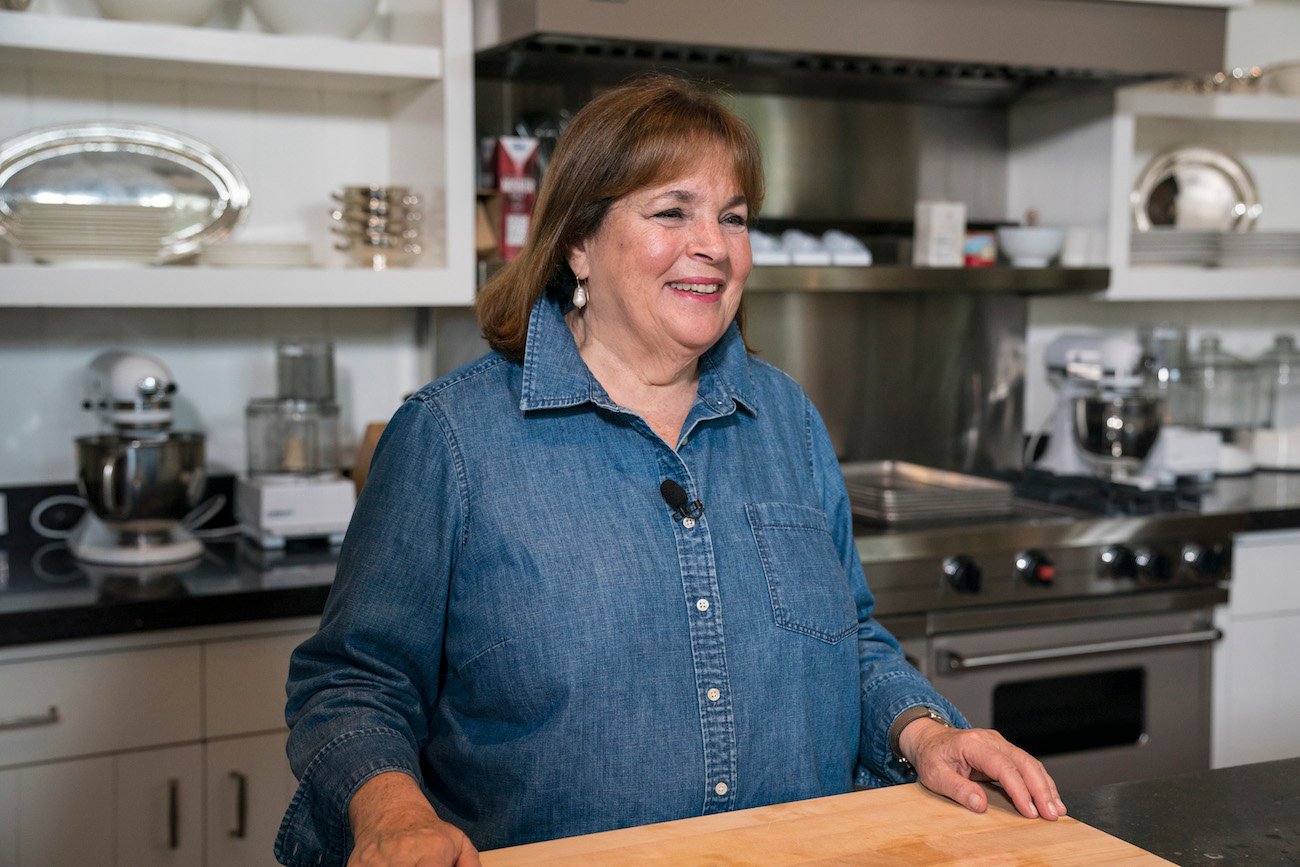 Ina Garten smiles and looks in a blue button-down shirt