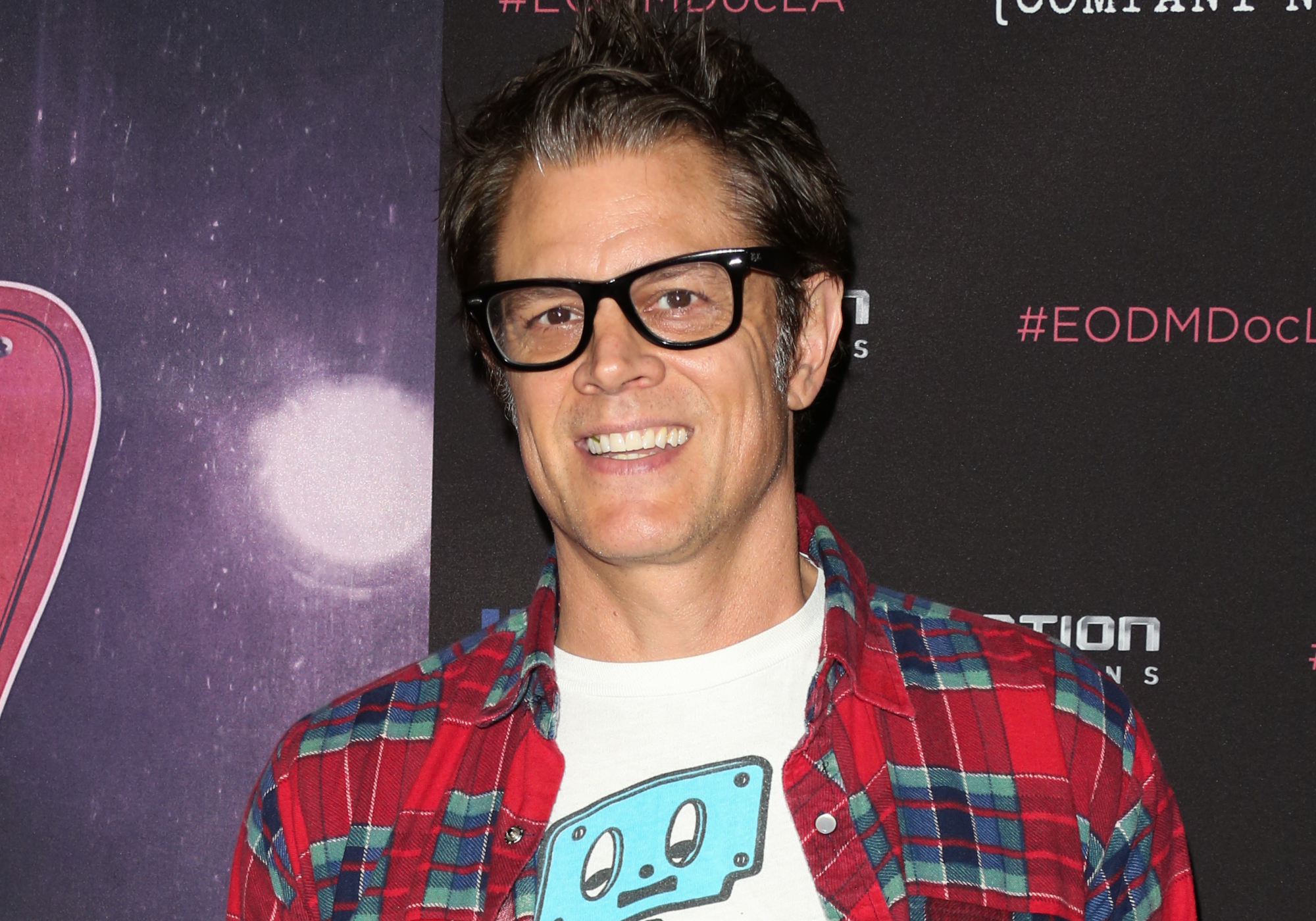 'Jackass Forever' star Johnny Knoxville standing in front of step and repeat