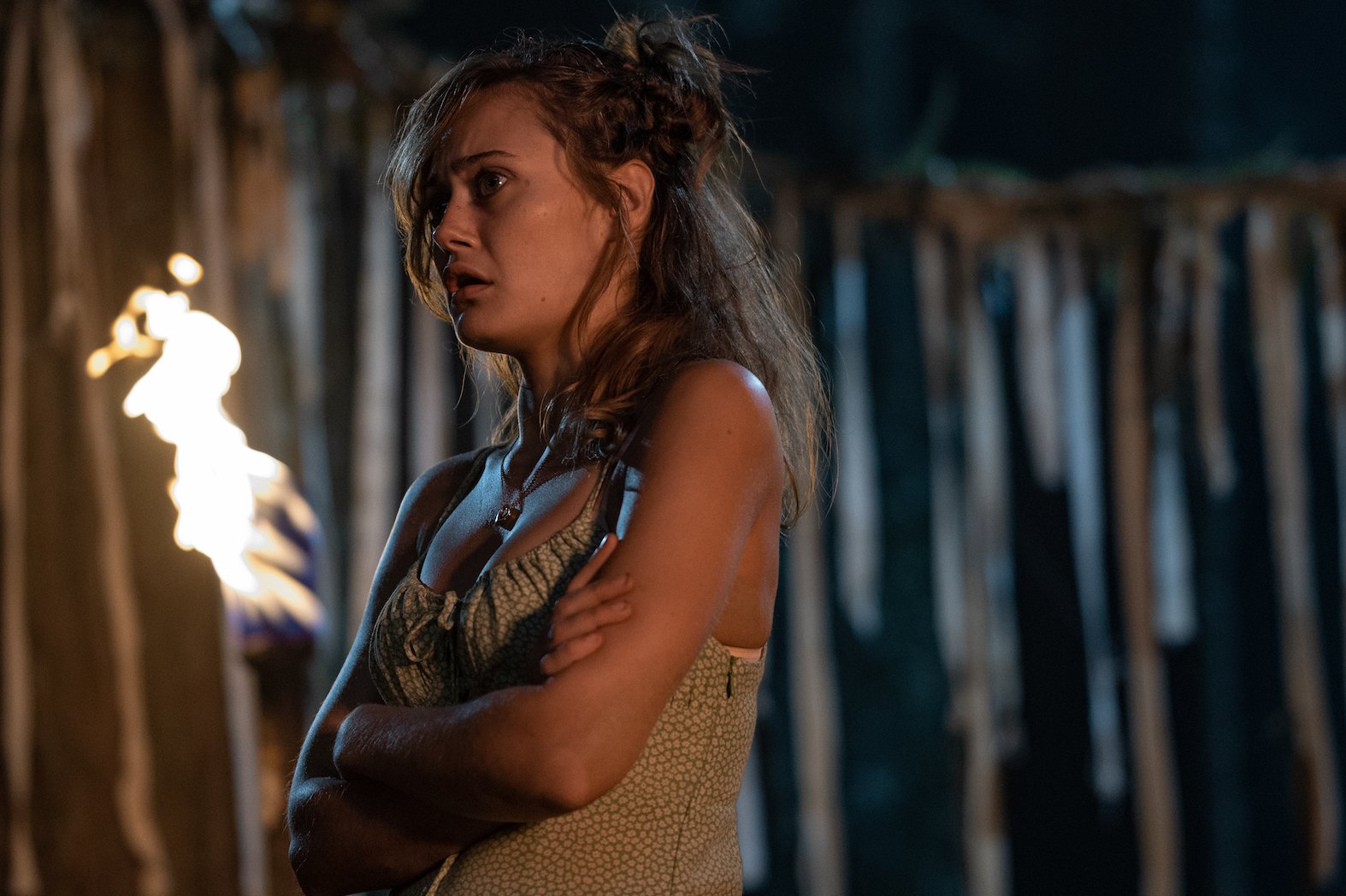 Ella Purnell as teen Jackie at night with her arms crossed looking scared in 'Yellowjackets'