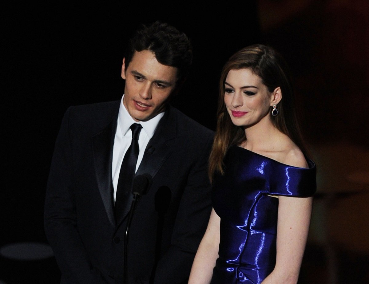 James Franco and Anne Hathaway posing in a suit and a blue dress.