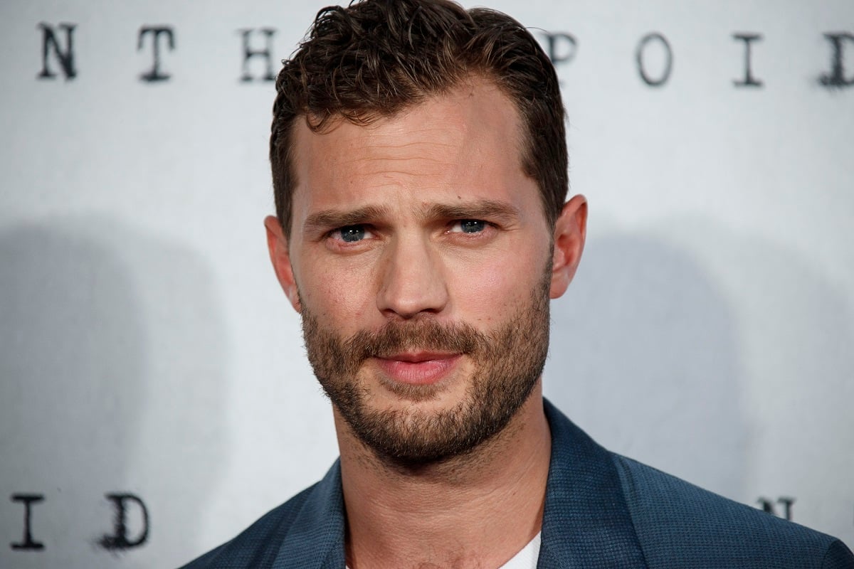 Jamie Dornan posing while wearing a suit.