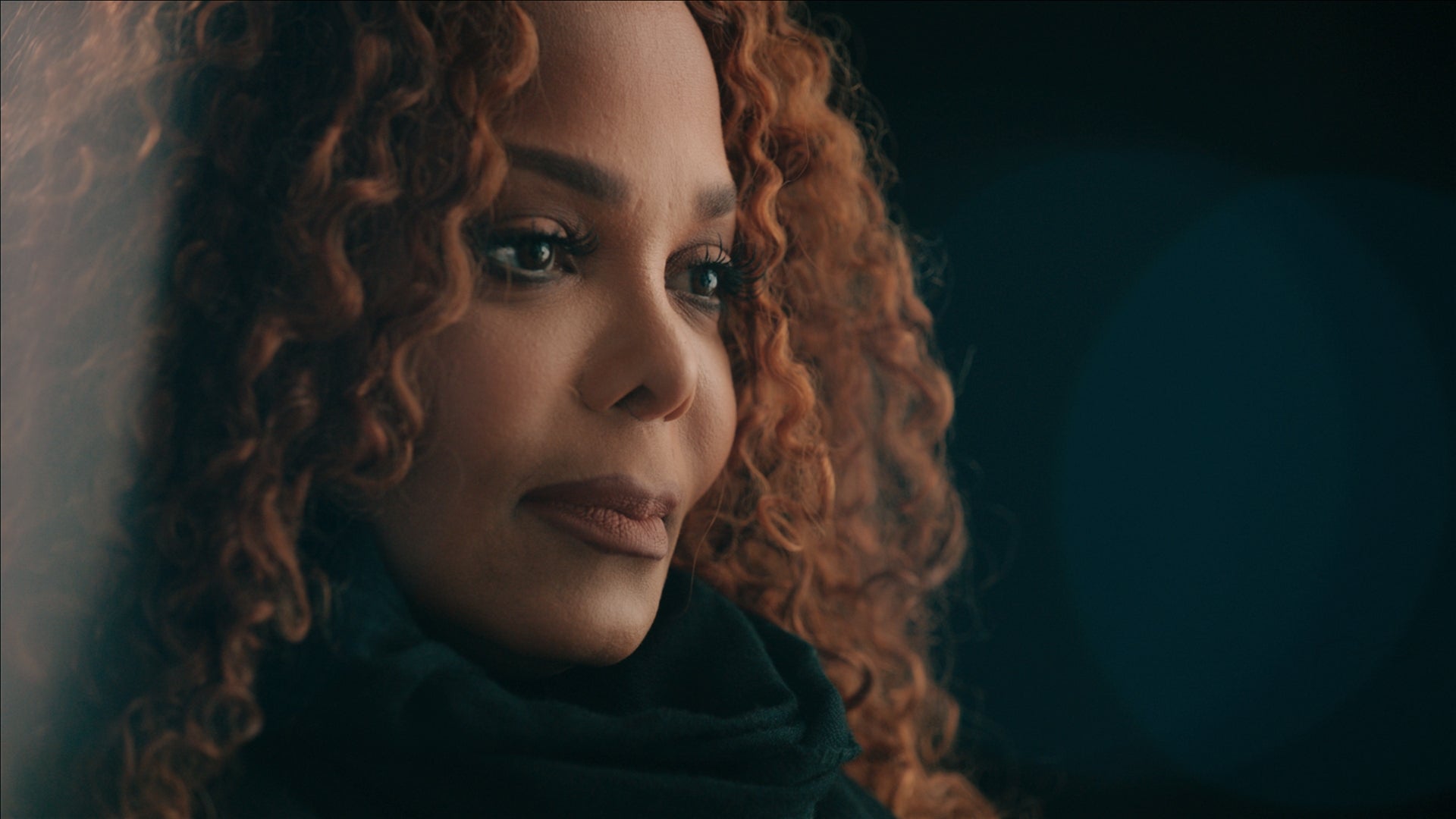 Janet Jackson in profile against black background in still from 'Janet Jackson' documentary