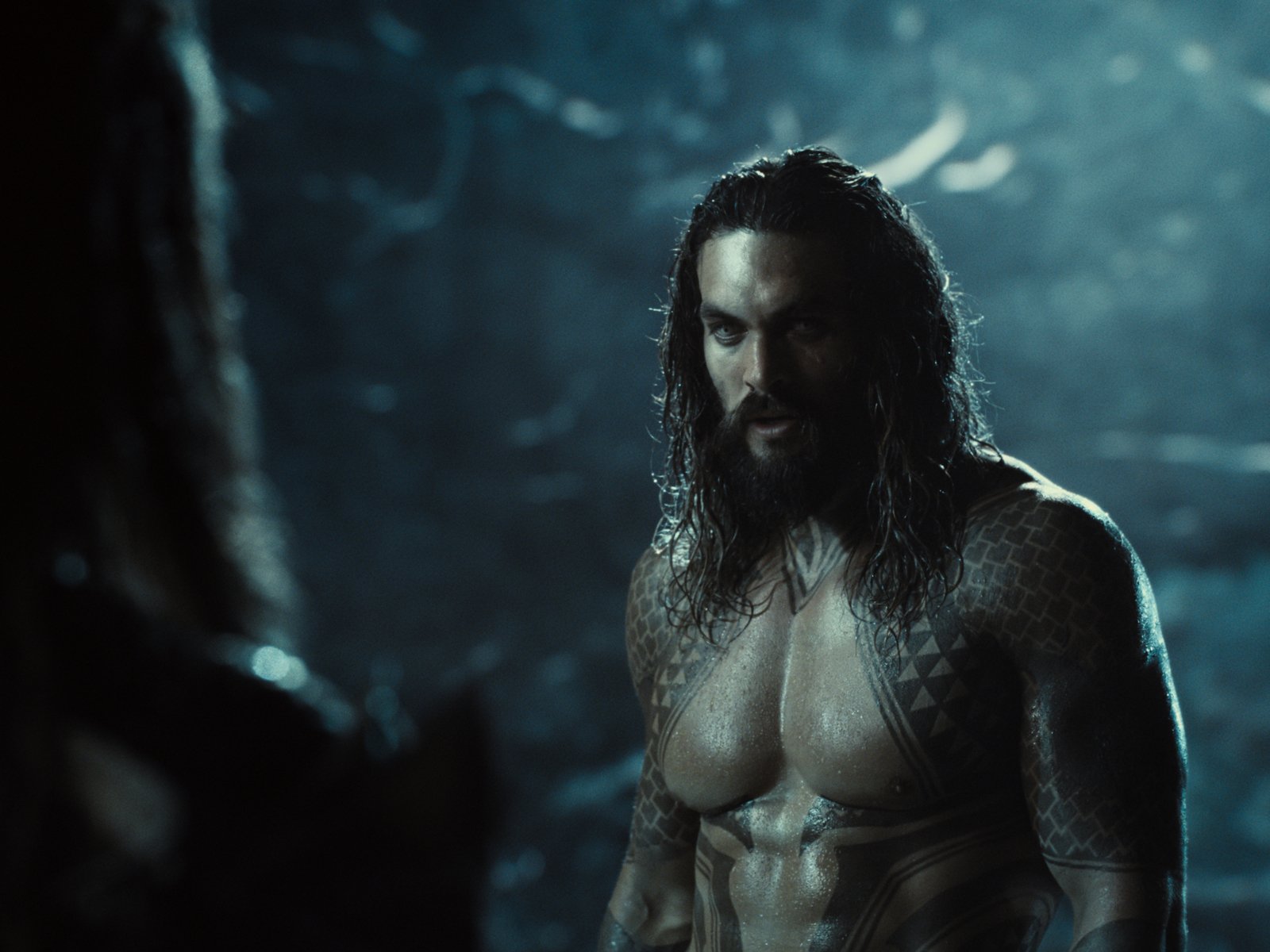 Jason Momoa as Aquaman in 'Zack Snyder's Justice League.' He's shirtless and staring at someone off-screen.