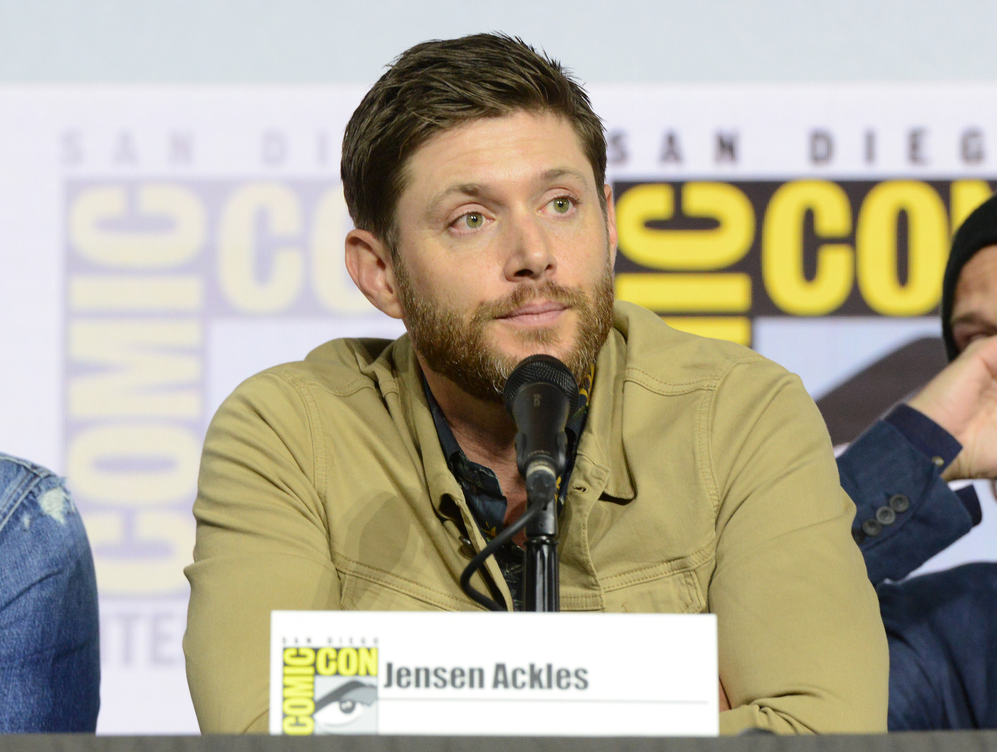 Jensen Ackles speaks into a microphone at a Comic-Con 'Supernatural' panel