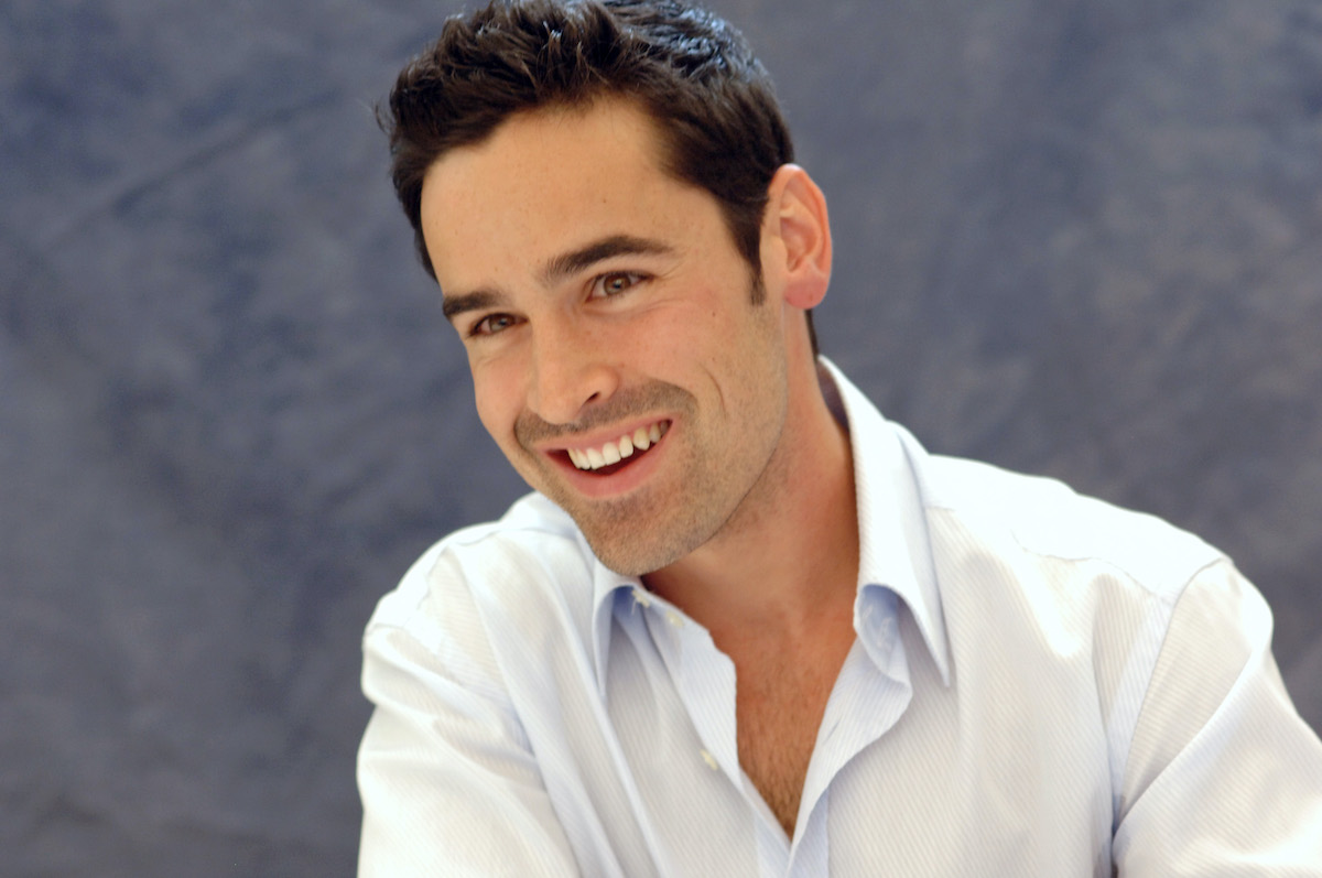 Jesse Bradford laughing in front of a gray background