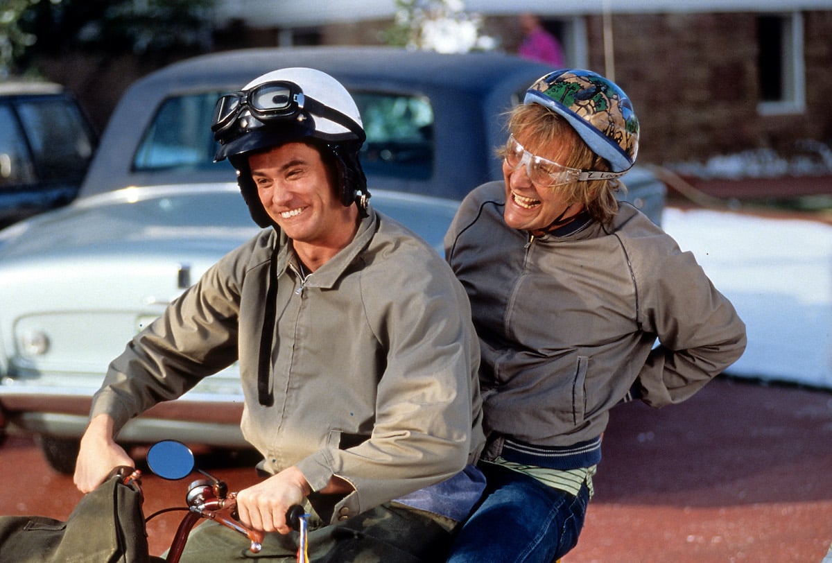 Jim Carrey and Jeff Daniels smile as they ride a bike in 'Dumb & Dumber'