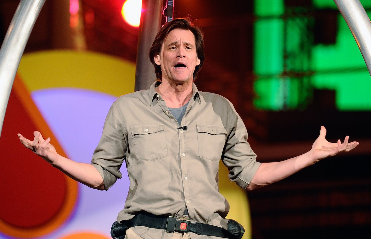 Jim Carrey wears a tan outfit as he poses with his arms outstretched at the Kids' Choice Awards