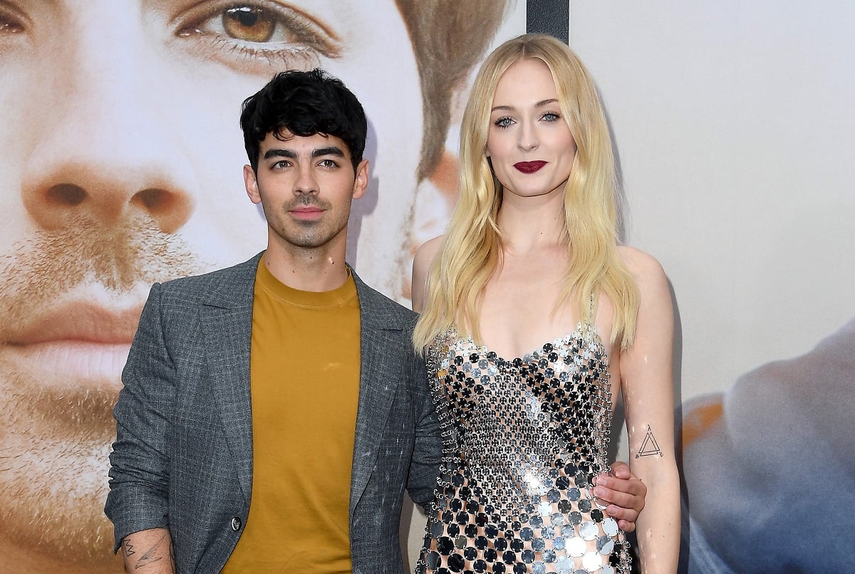 Joe Jonas and Sophie Turner posing arm in arm on the red carpet at a movie premiere