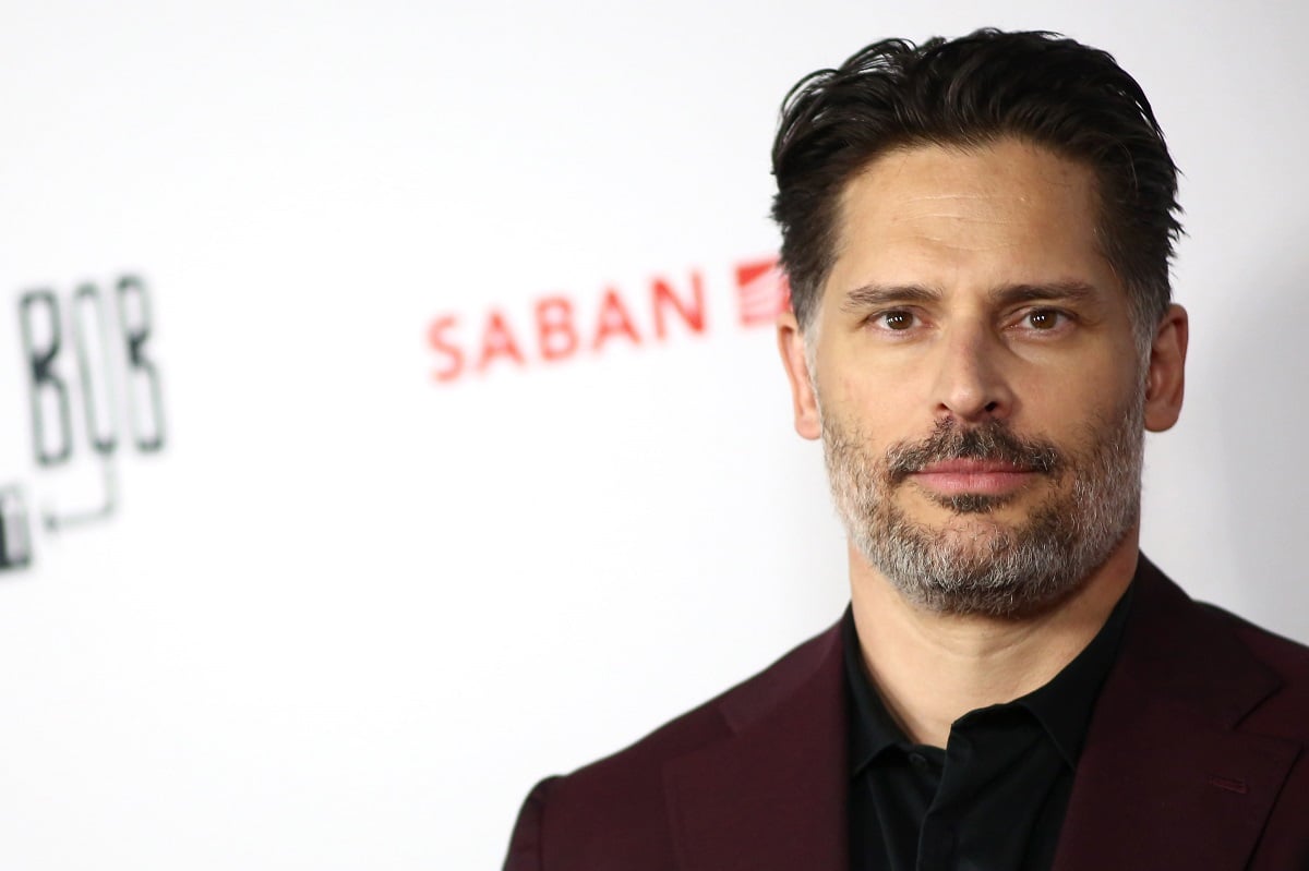 Joe Manganiello posing in a black suit.