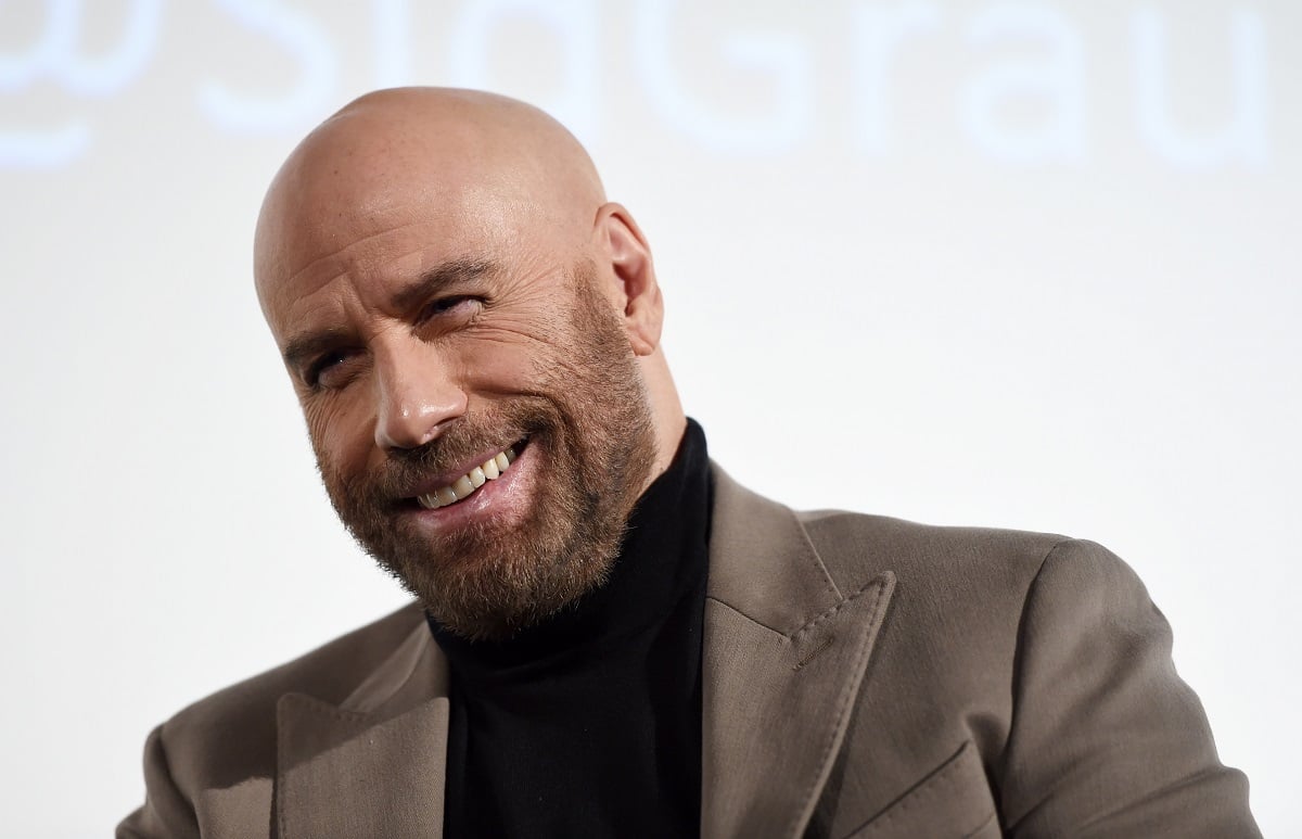 John Travolta smiling while wearing a turtle neck.