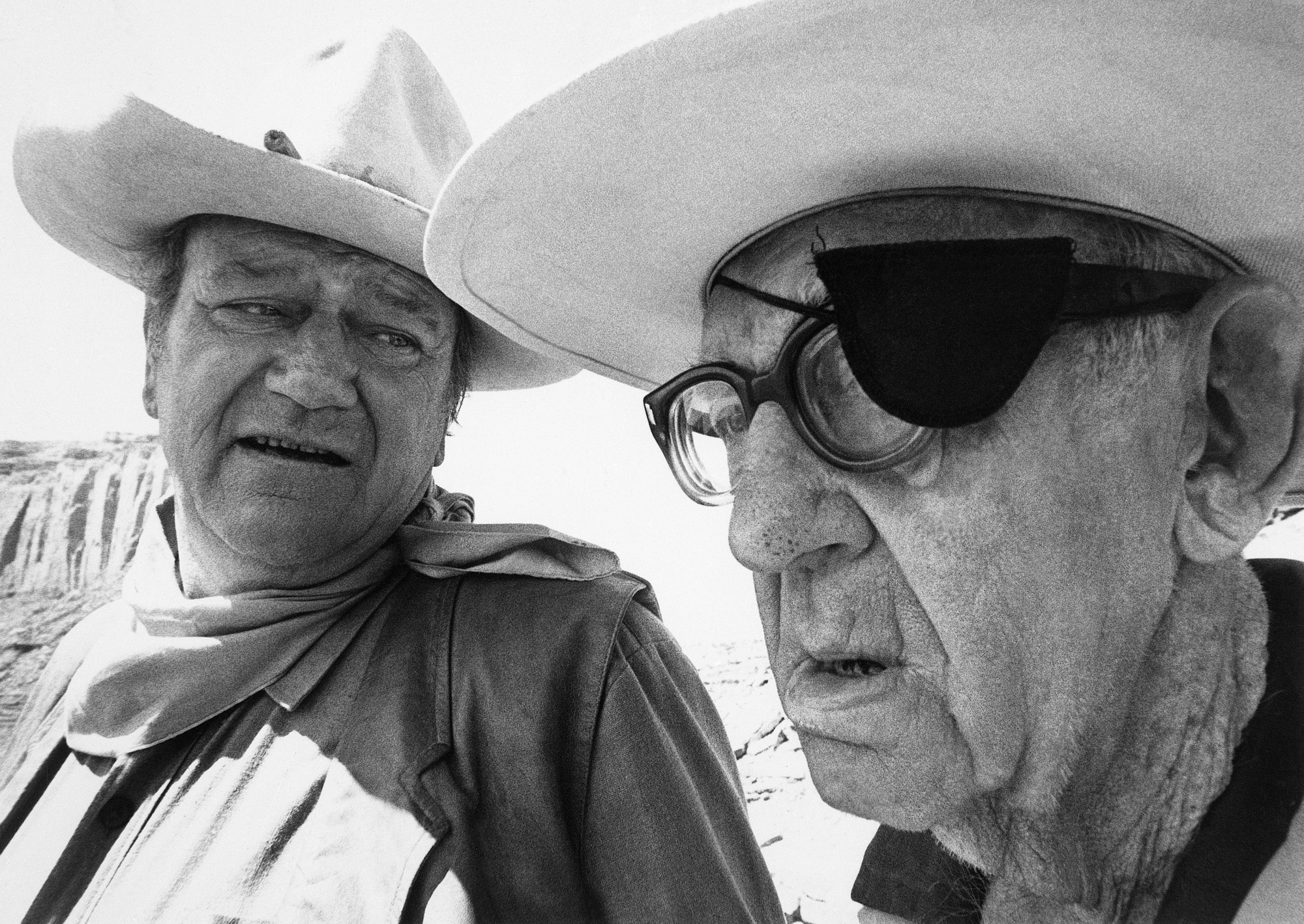 John Wayne and John Ford talking while wearing cowboy hats
