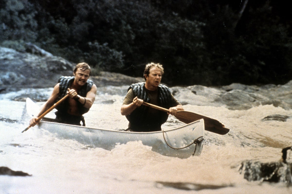 Jon Voight and Ned Beatty canoe down a raging river while filming a scene for 1972's 'Deliverance'