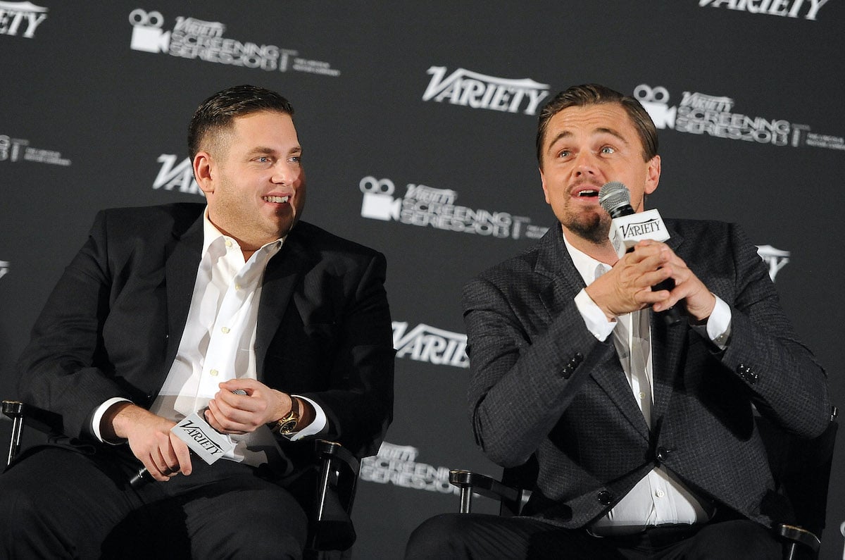 Jonah Hill looks on as Leonardo DiCaprio speaks onstage