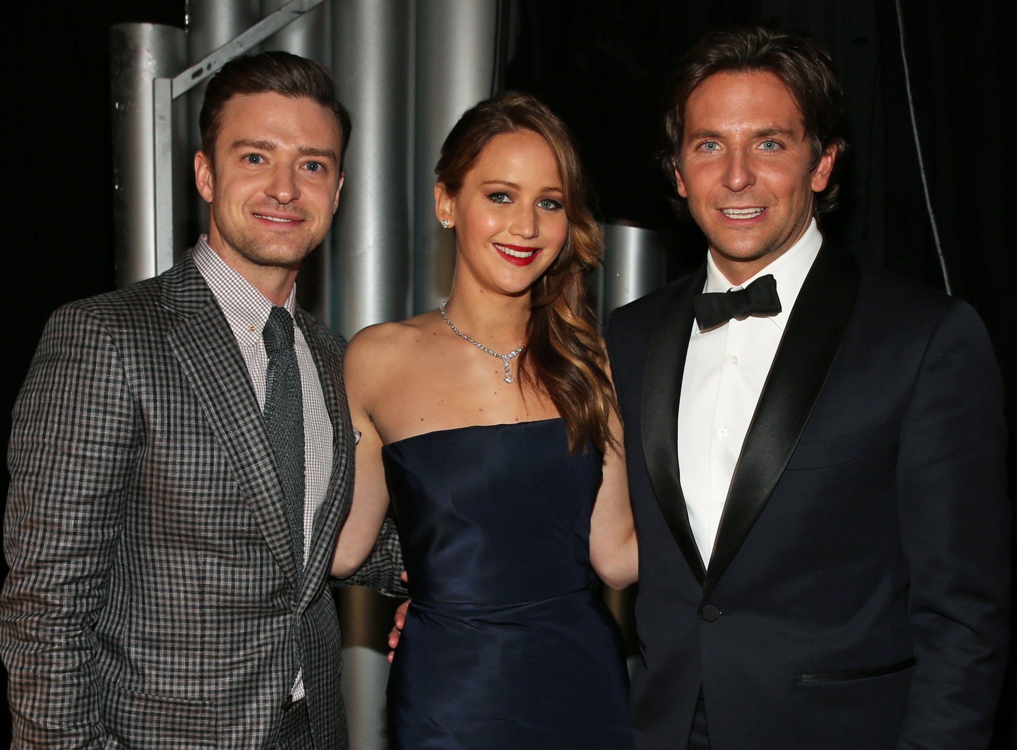 Justin Timberlake, Jennifer Lawrence, and Bradley Cooper with Lawrence's arms behind Timberlake and Cooper