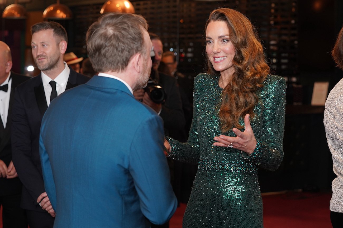Kate Middleton wears a green sequin gown as she speaks to comedian Chris McCausland