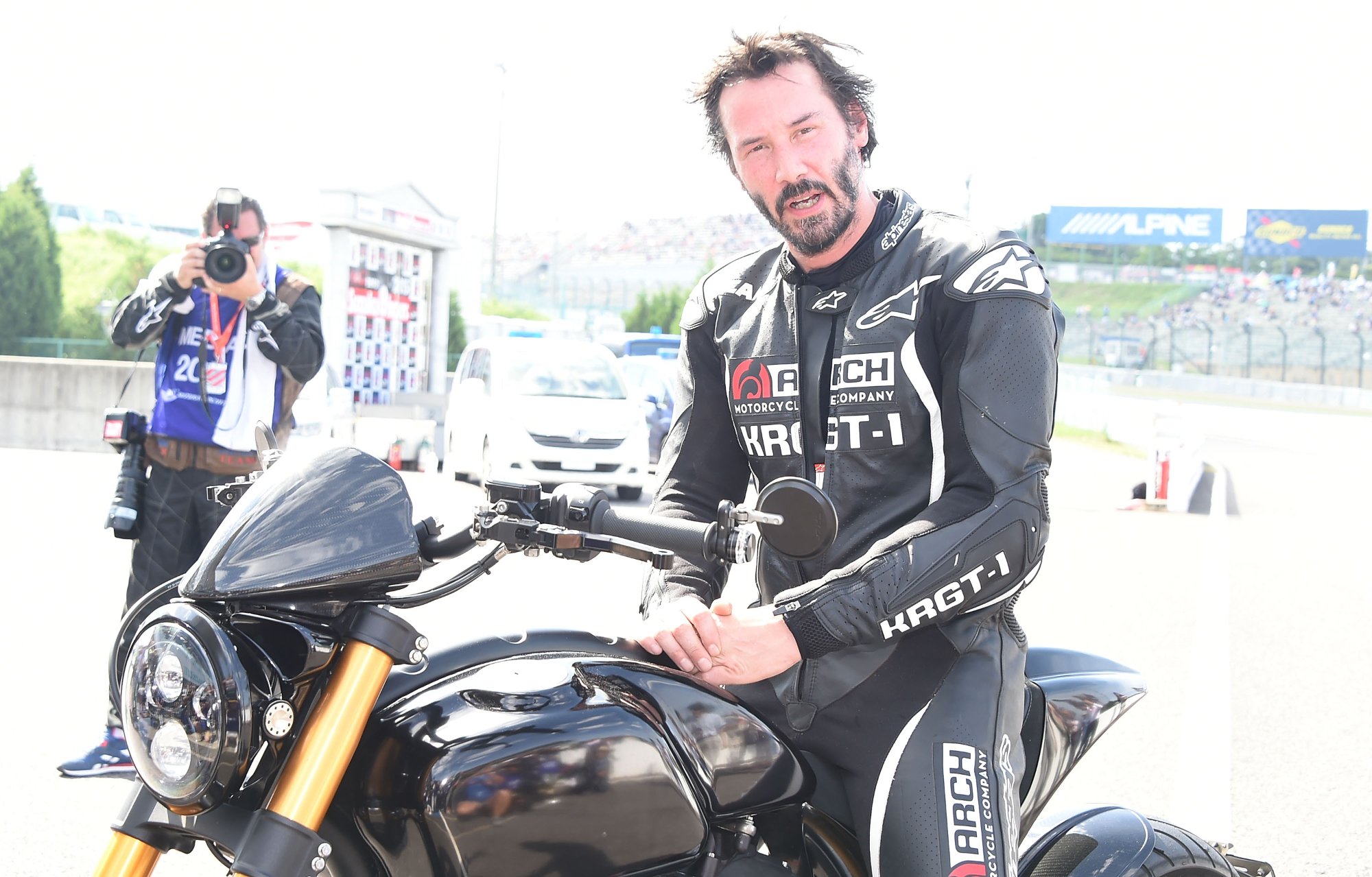 Keanu Reeves on motorcycle in article about an accident sitting on the bike wearing black