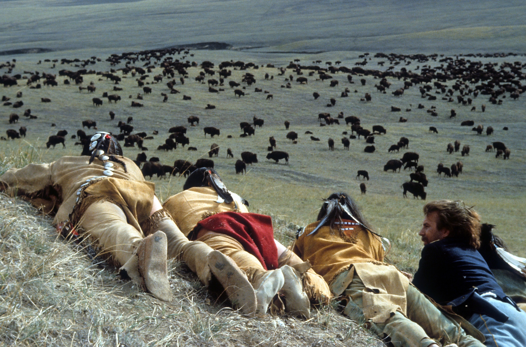 Kevin Costner as John Dunbar with Sioux Indians in 'Dances With Wolves' laying on the the hill observing the buffalo