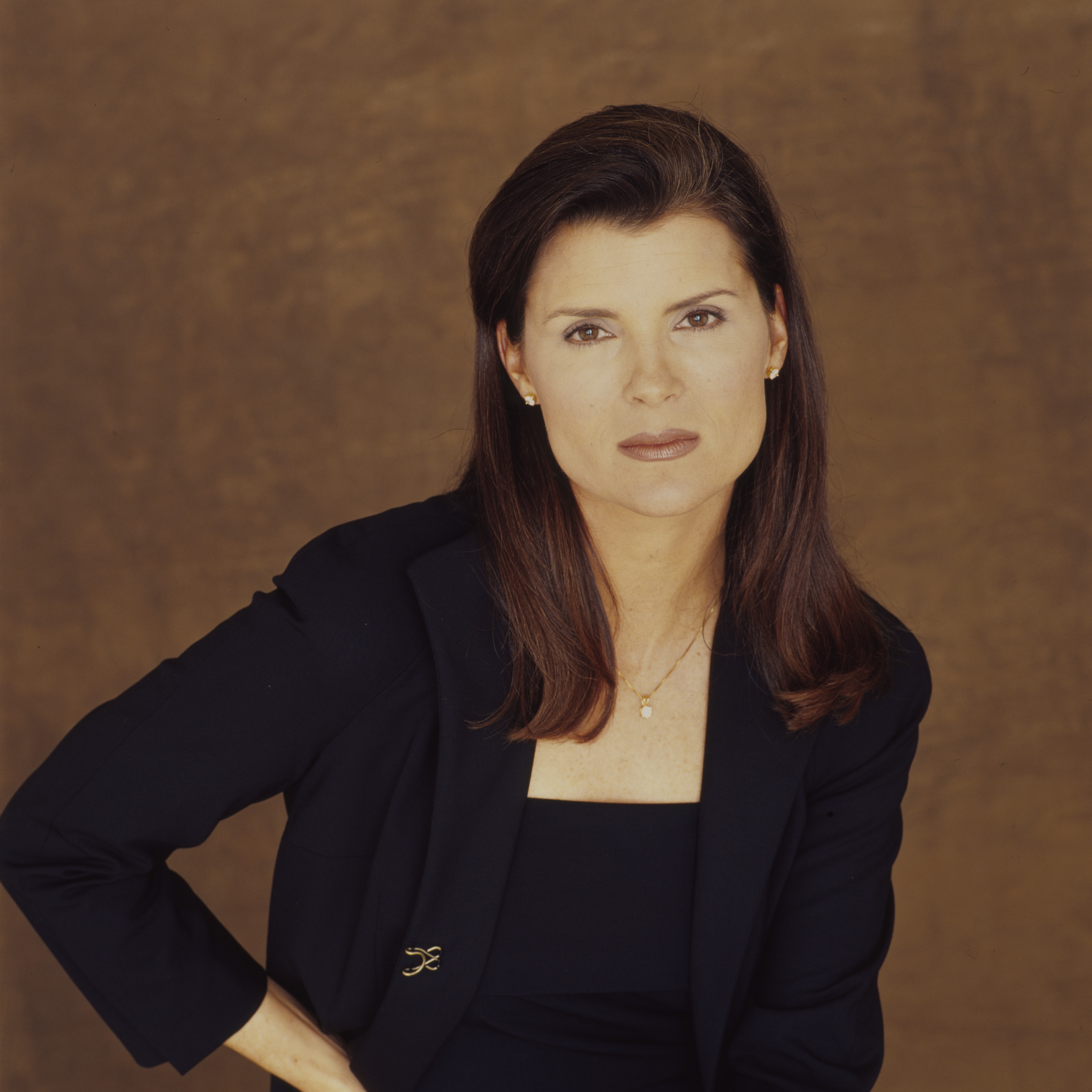 'The Bold and the Beautiful' actor Kimberlin Brown wearing a navy blue suit and standing in front of a black backdrop.