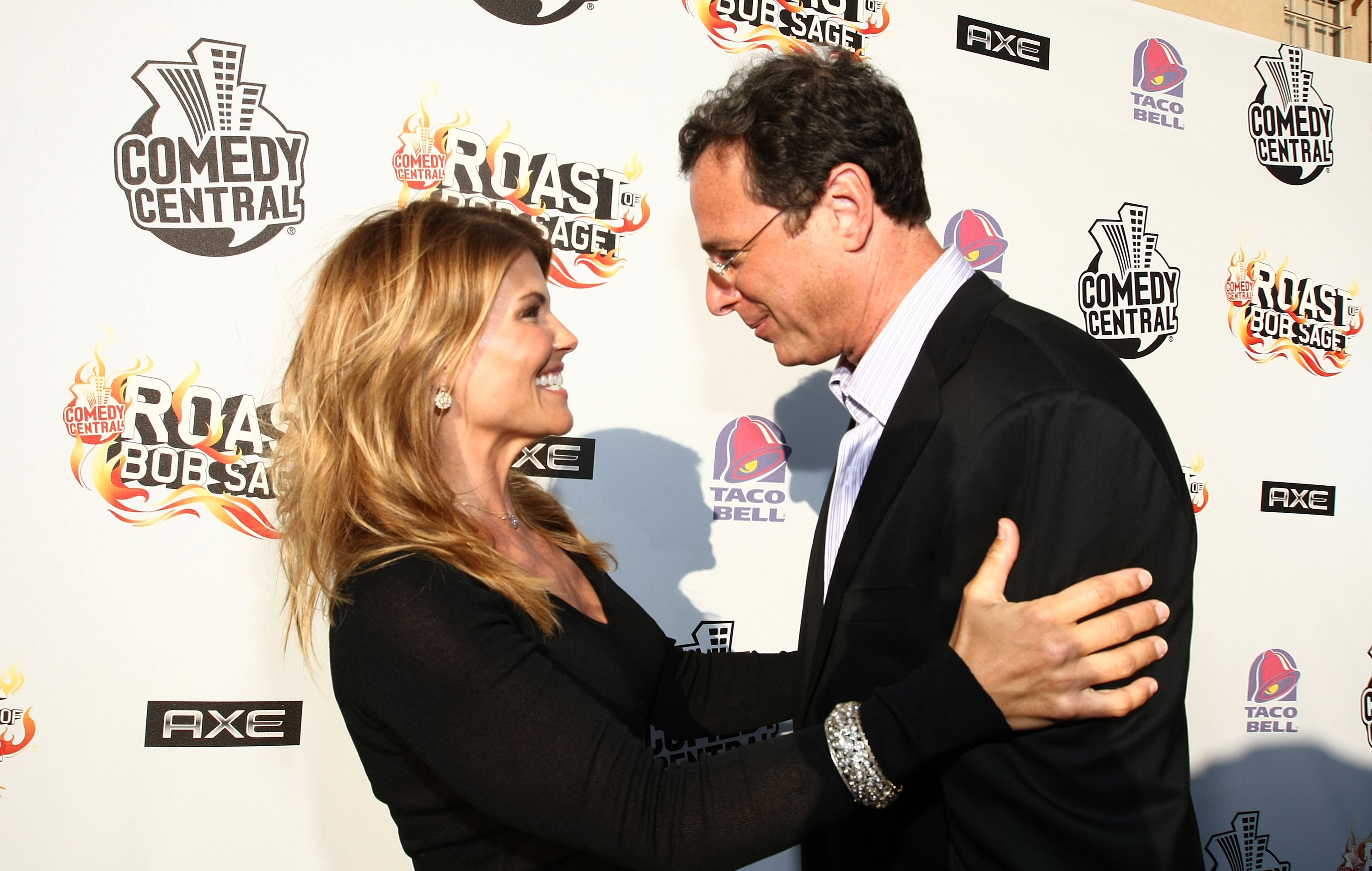 Lori Loughlin and Bob Saget smiling at each other