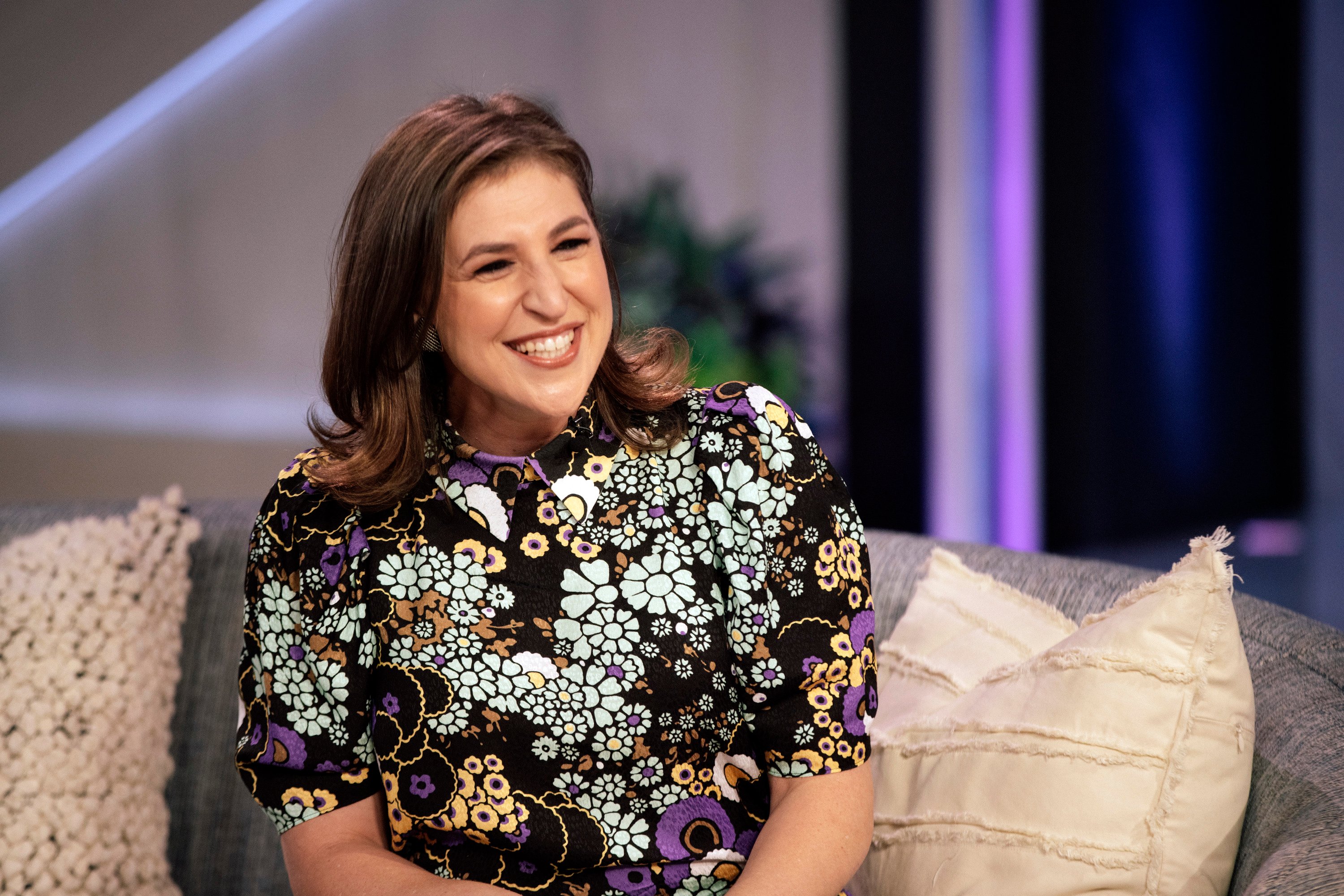Actor and Jeopardy! host Mayim Bialik wears a short-sleeve floral dress in an appearance on The Kelly Clarkson Show