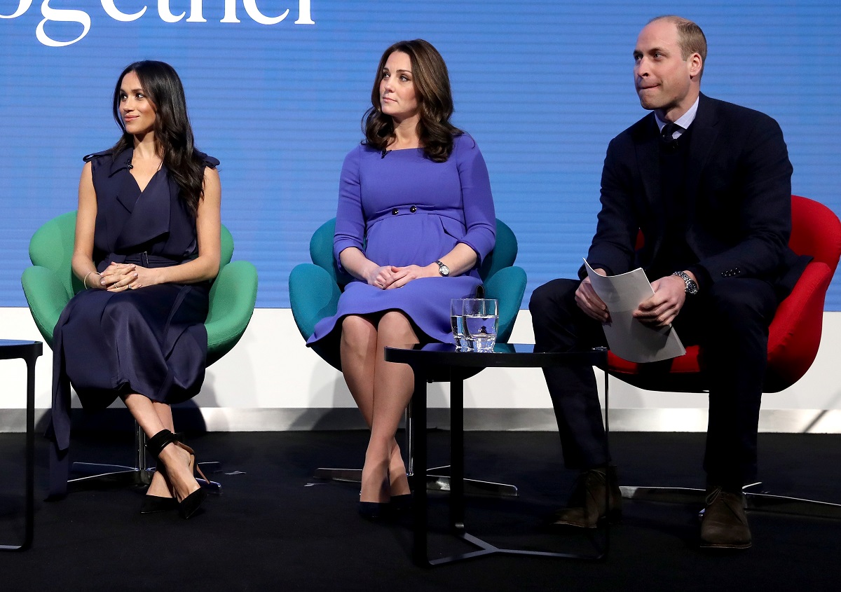 Meghan Markle, Kate Middleton, and Prince William sitting onstage at the Royal Foundation Forum