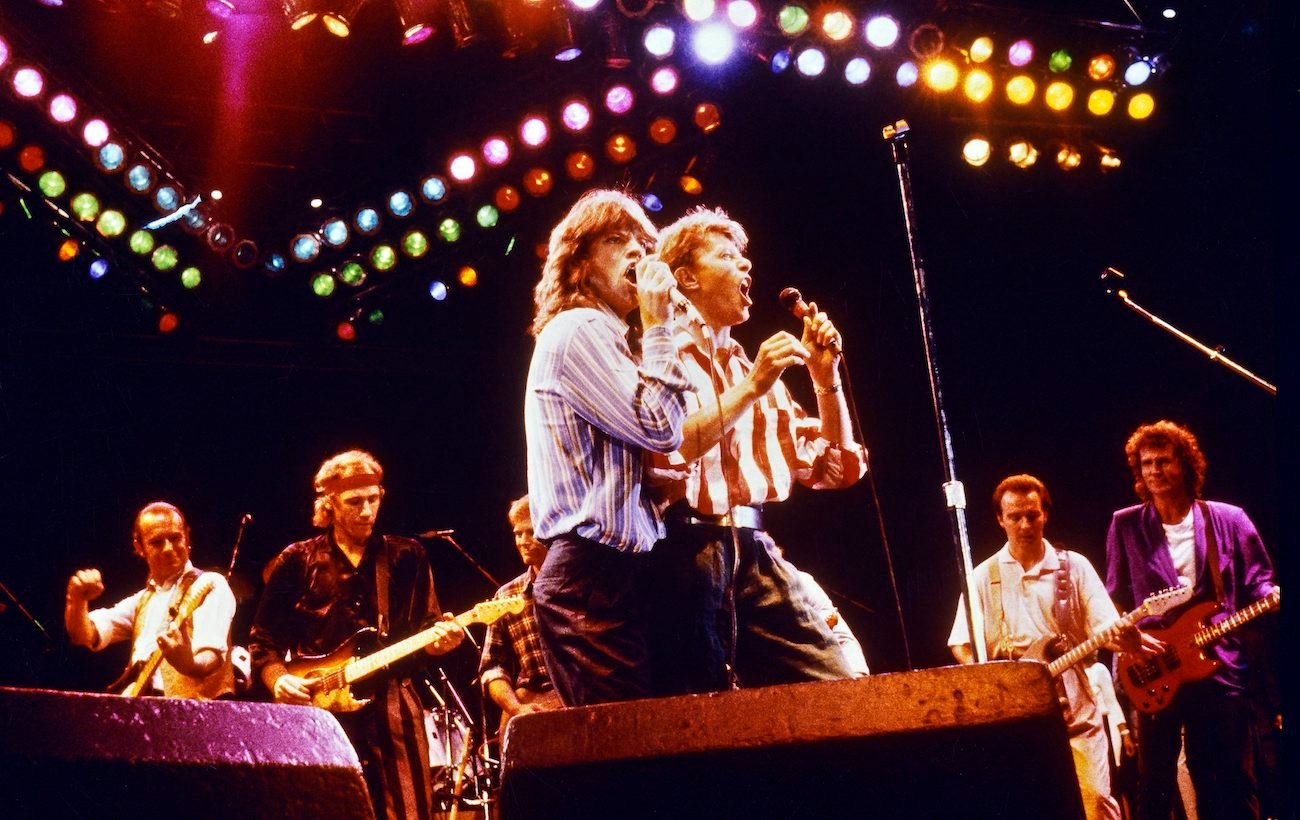 Mick Jagger and David Bowie embracing while performing together at the Prince's Trust 10th birthday concert in 1986.