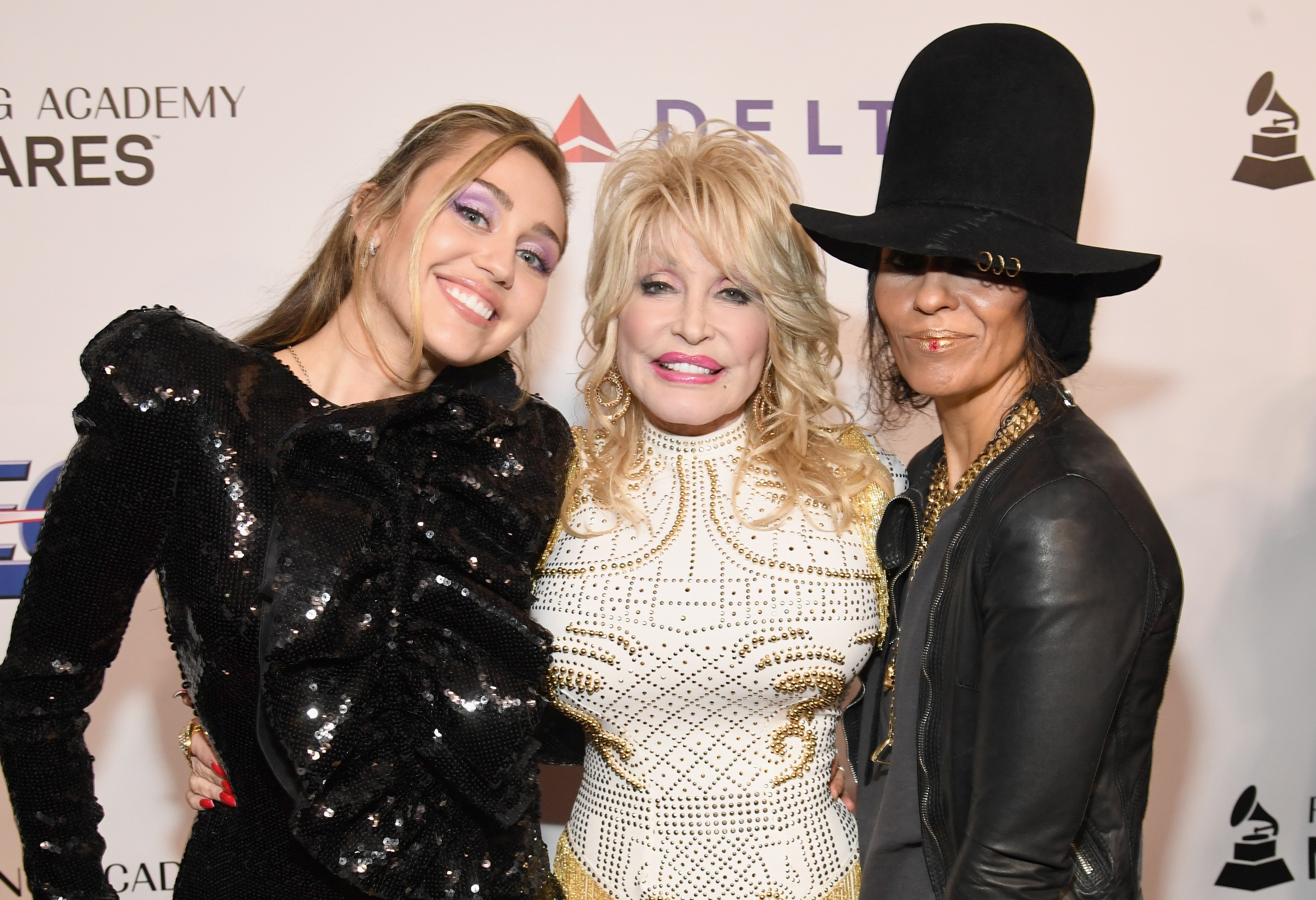 Miley Cyrus, Dolly Parton, and Linda Perry pose for a picture at the  MusiCares Person of the Year event honoring Dolly Parton at the Los Angeles Convention Center