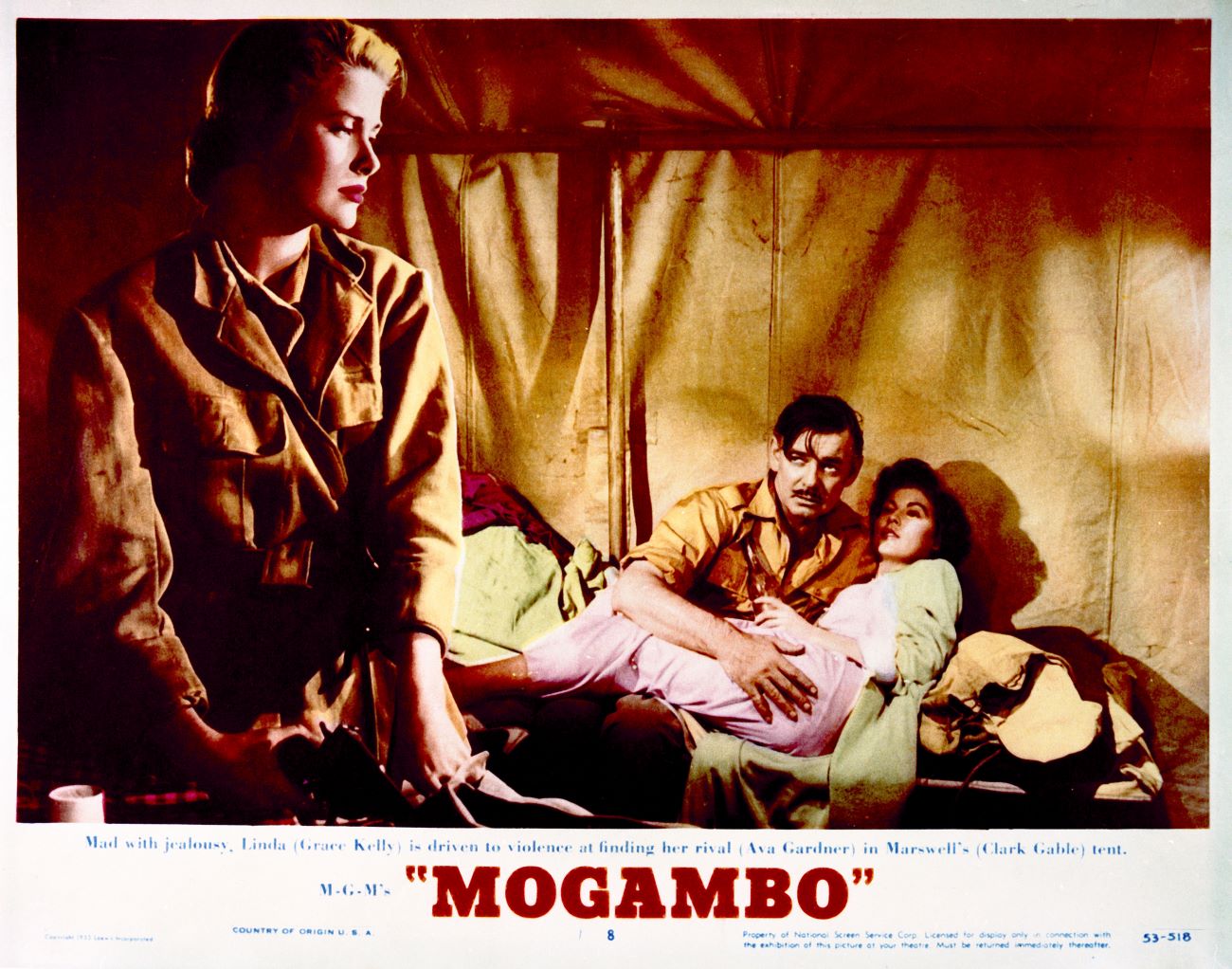 A poster for 'Mogambo' where Grace Kelly looks away as Clark Gable and Ava Gardner lay in bed together.