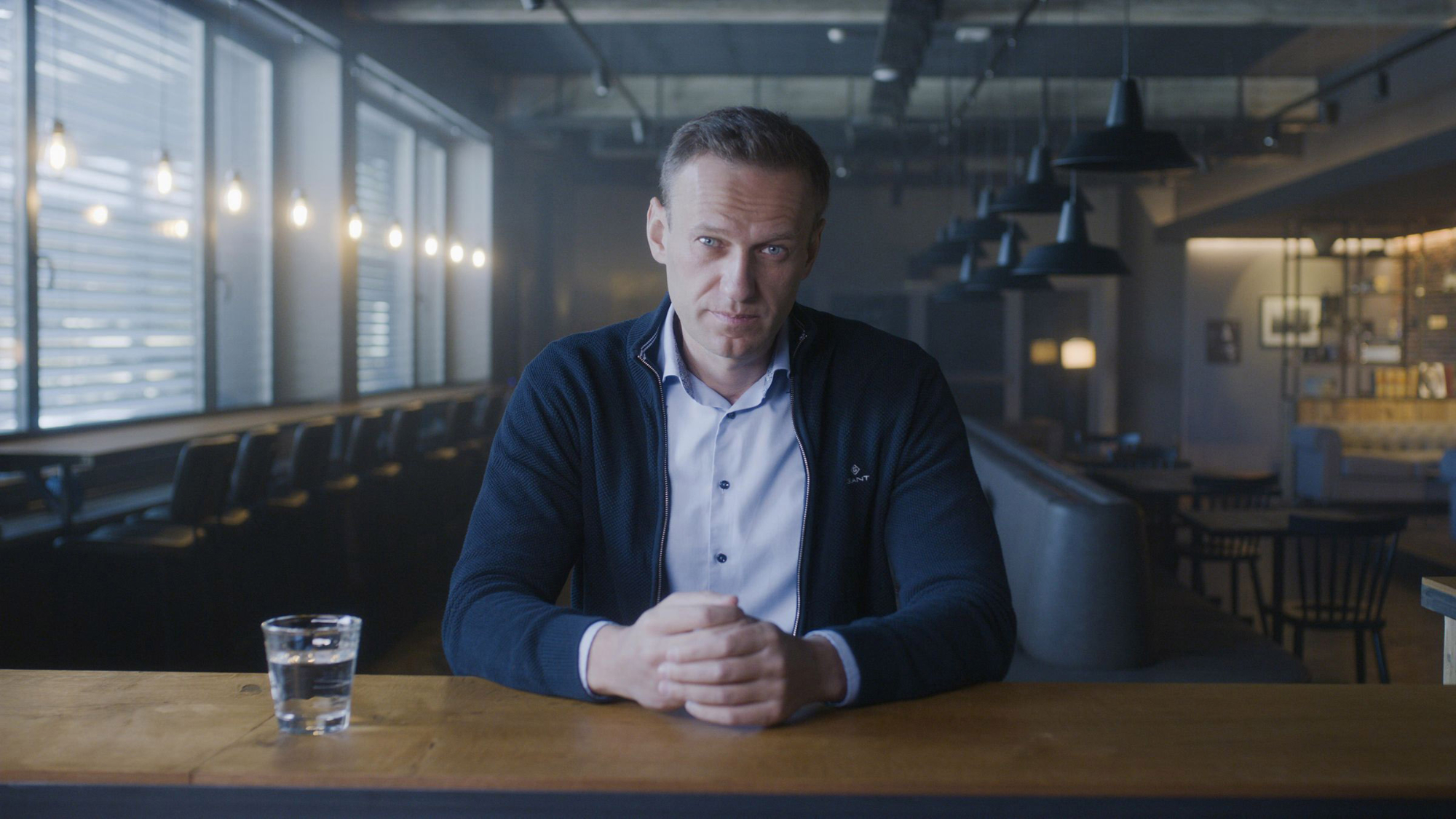 'Navalny' review Alexei Navalny sitting with his hands folded next to a glass of water