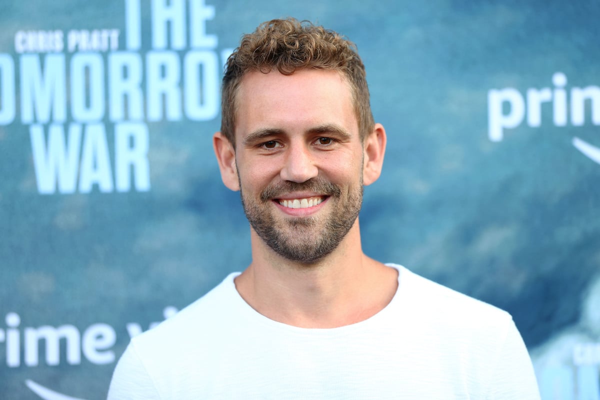 Nick Viall smiling in front of a blue background