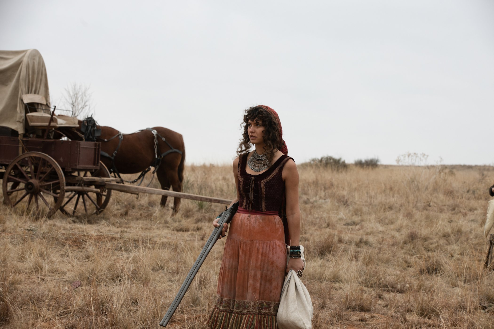 Gratiela Brancusi as Noemi alone outside in front of a wagon with horses in '1883'