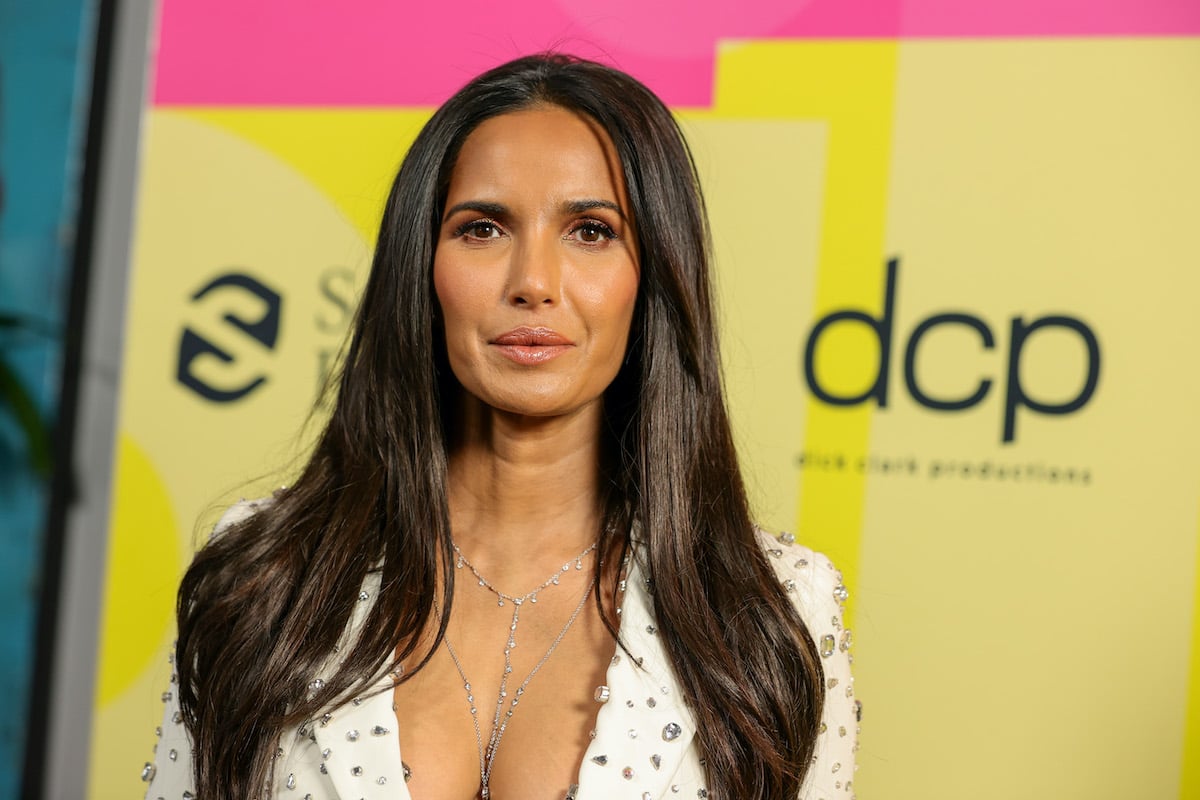 Padma Lakshmi in front of a yellow and pink background