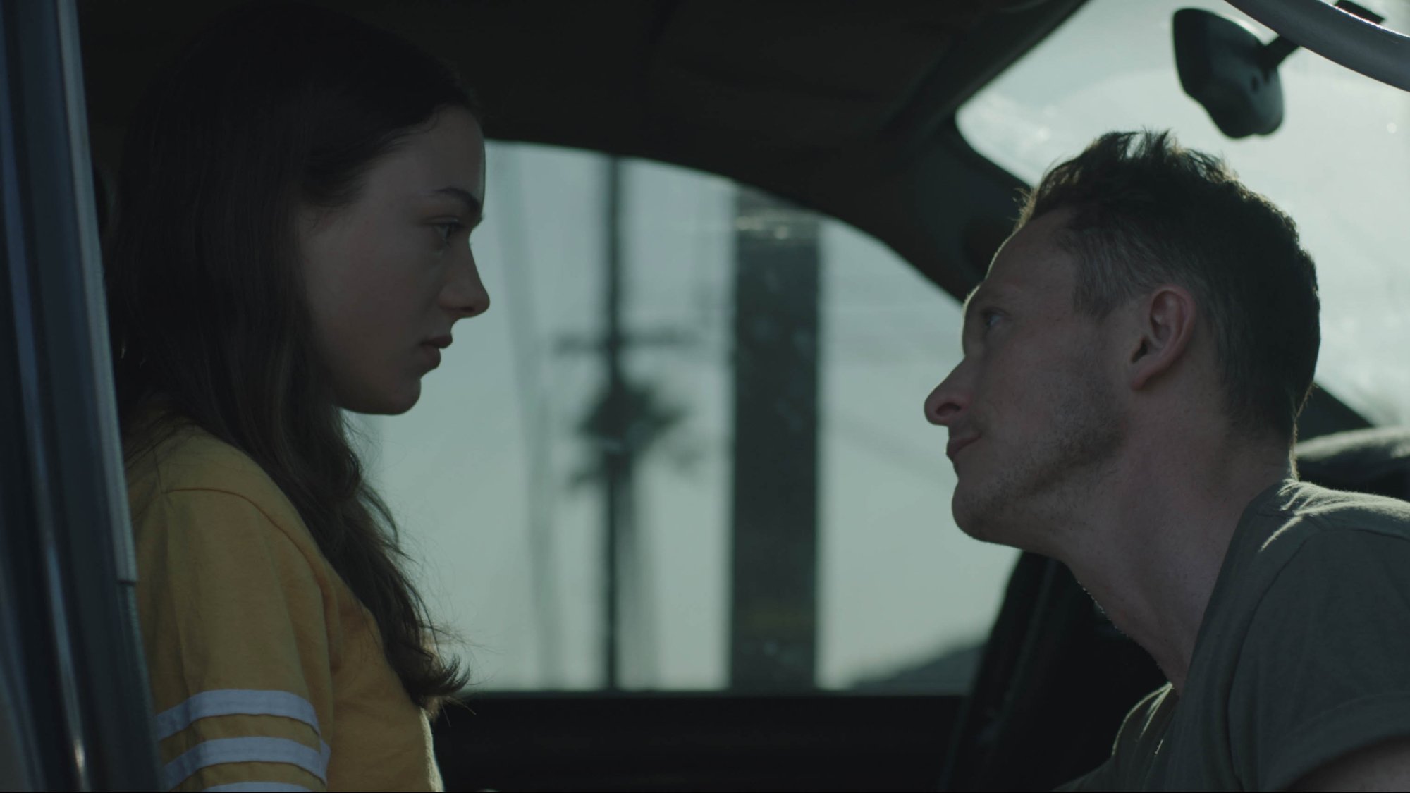 'Palm Trees and Power Lines' review Lily McInerny as Lea and Jonathan Tucker as Tom looking at each other in the car