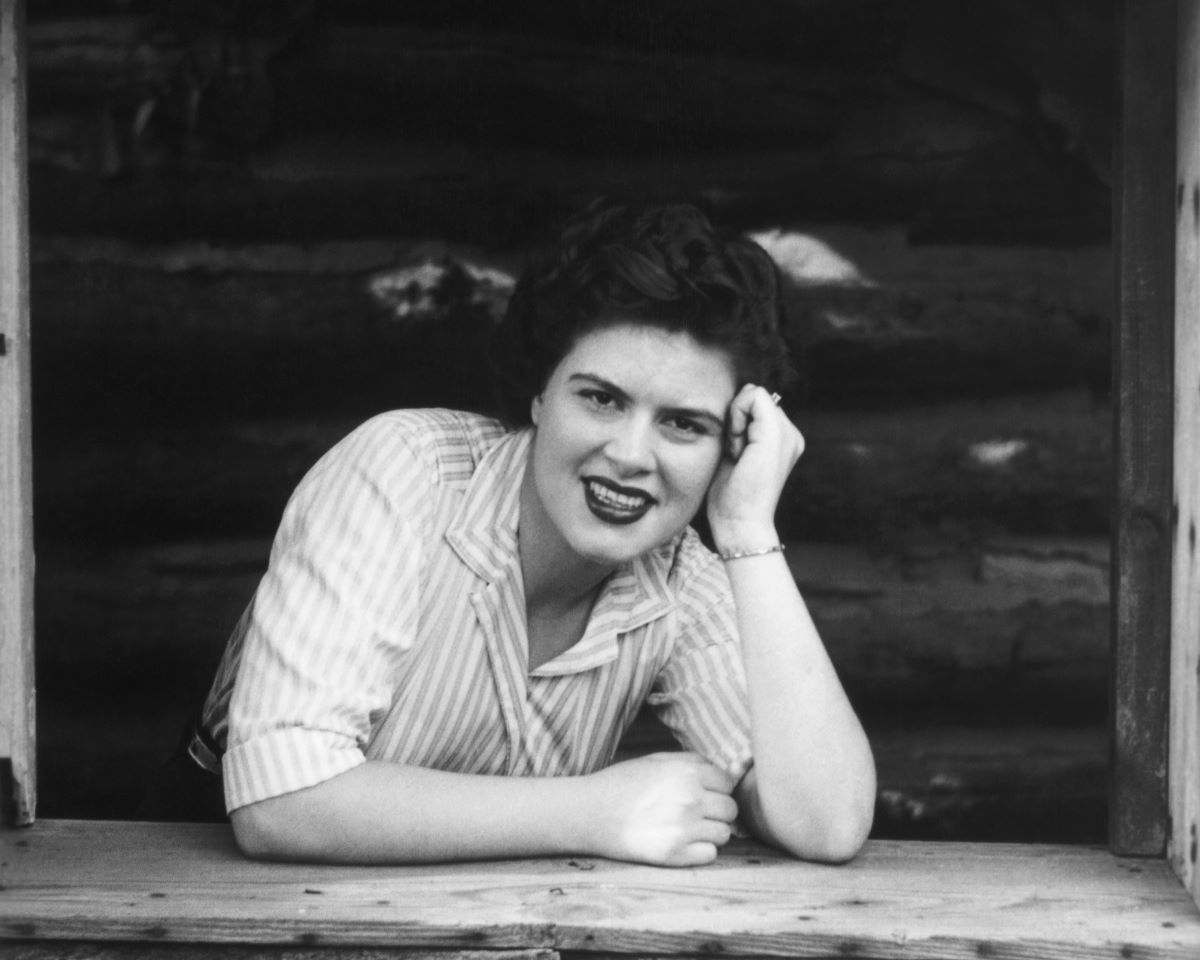 Patsy Cline in a black and white photo, leaning her head on one hand