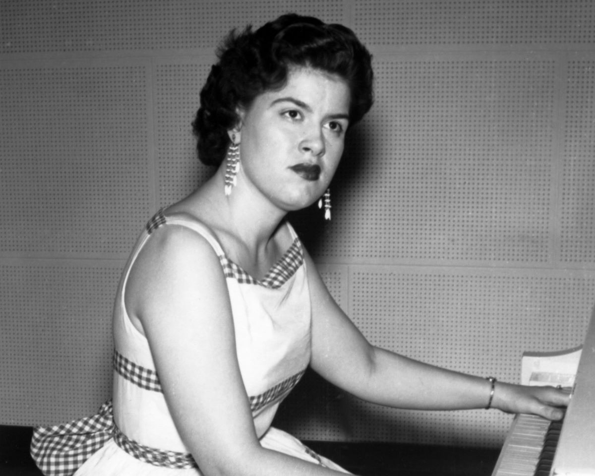 Black and white photo of Patsy Cline seated at a piano, c. 1957
