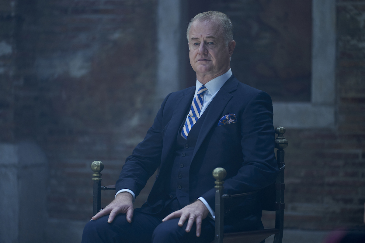 Peter Knox sitting in a chair in 'A Discovery of Witches' Season 3