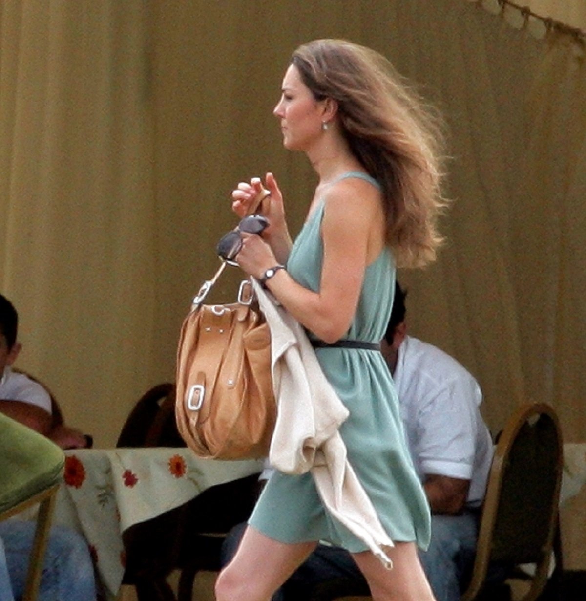 Kate Middleton attending the Chakravarty Cup polo match walking in a green dress holding a large brown handbag