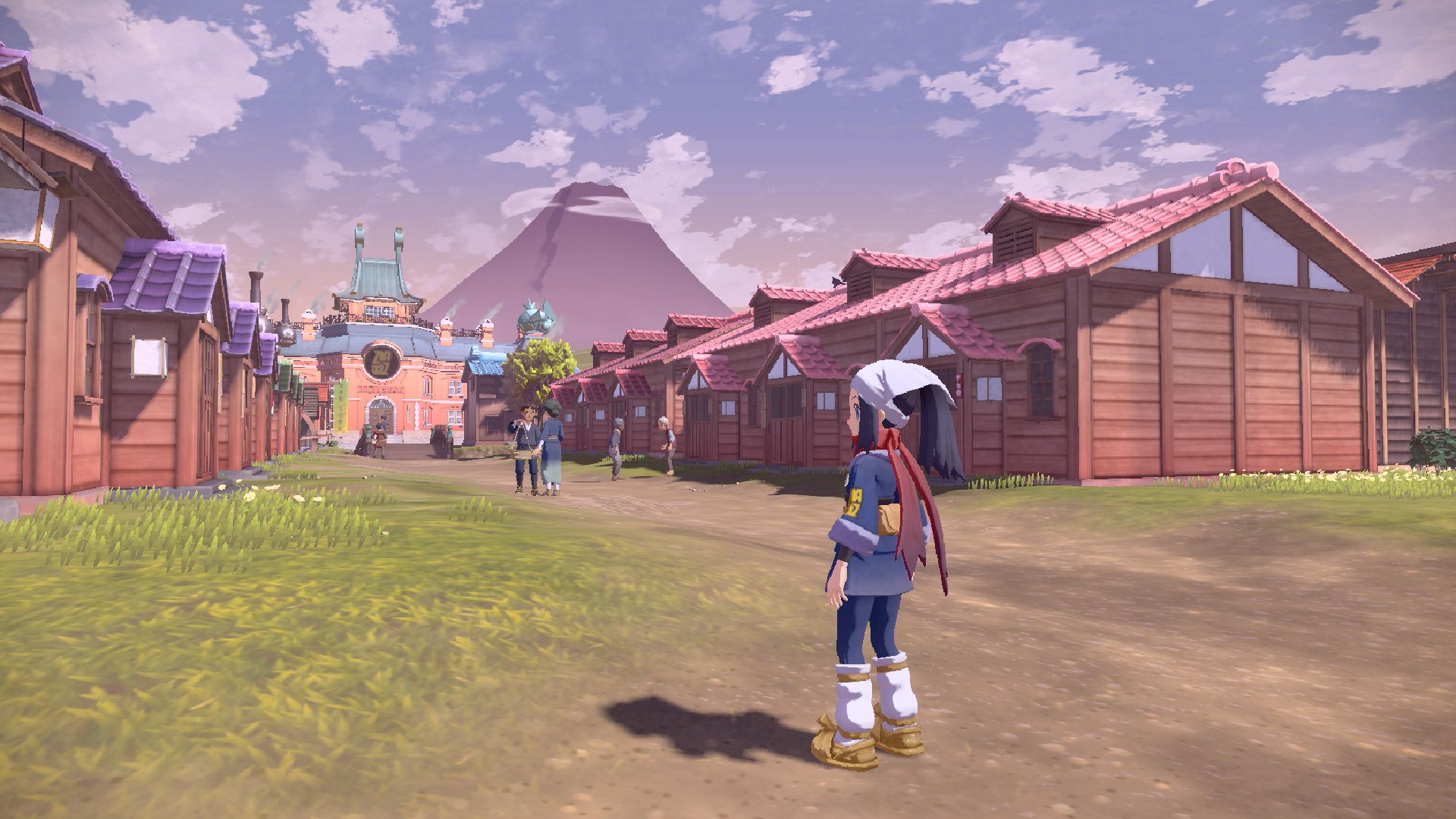 'Pokémon Legends: Arceus' screenshot showing avatar staring at a row of cabins in front of a mountain.