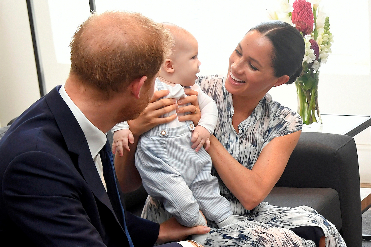 Prince Harry looking at Meghan Markel holding baby Archie